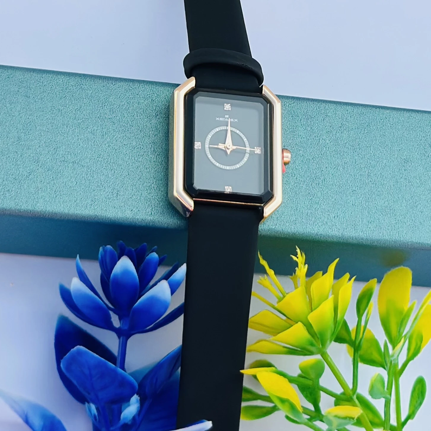 women's watch with a rectangular dial and a black strap.