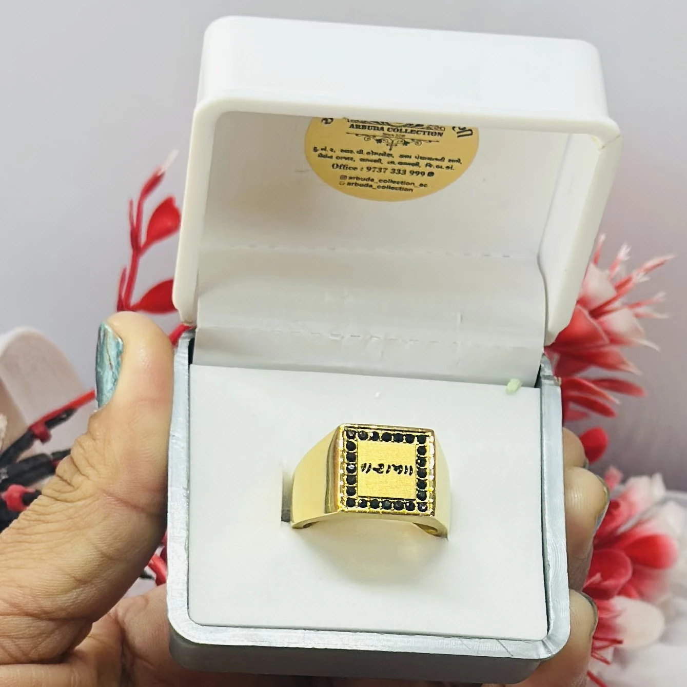 Gold -toned men's signet ring with black accent stones and engraved text.