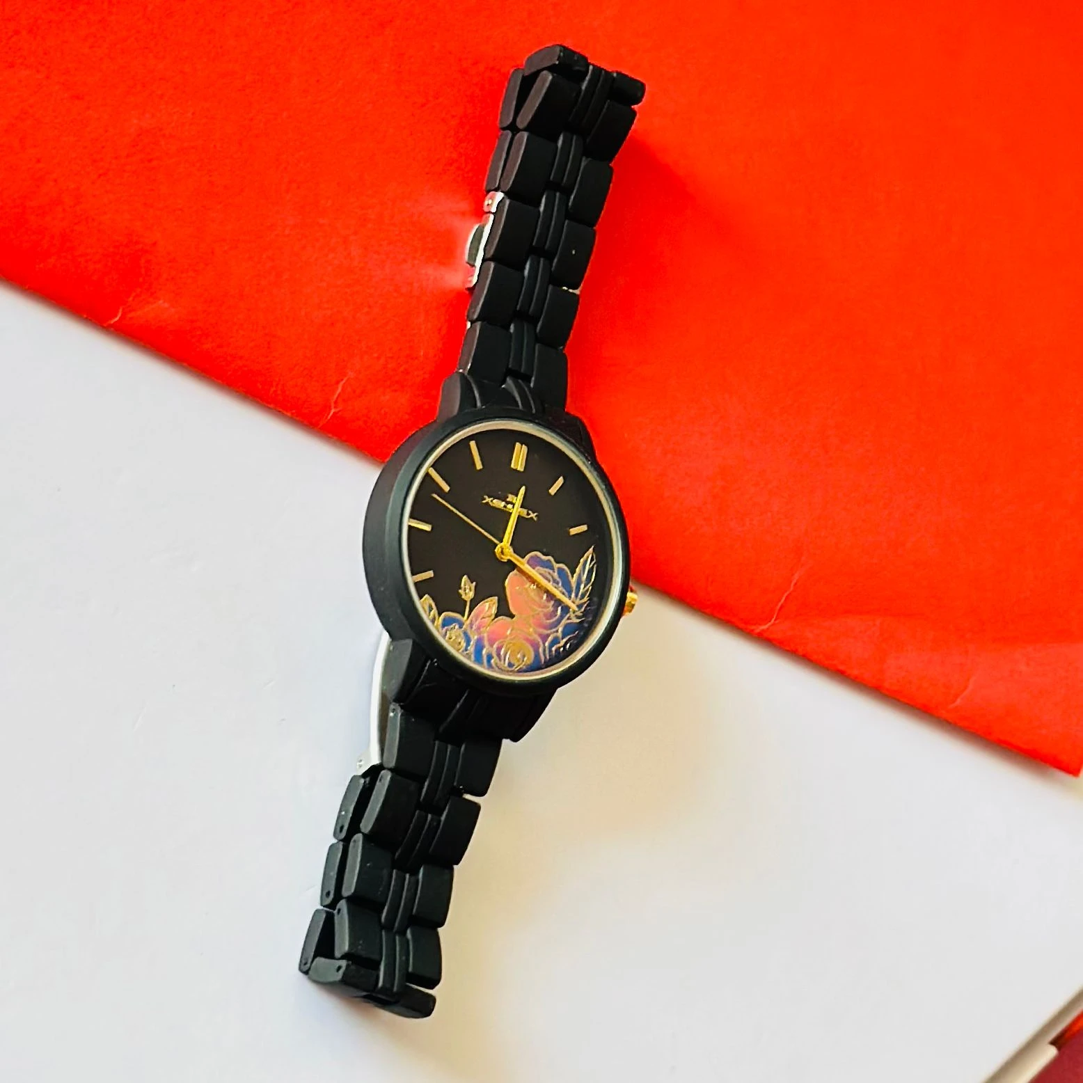 black metal analogue watch with a floral dial design