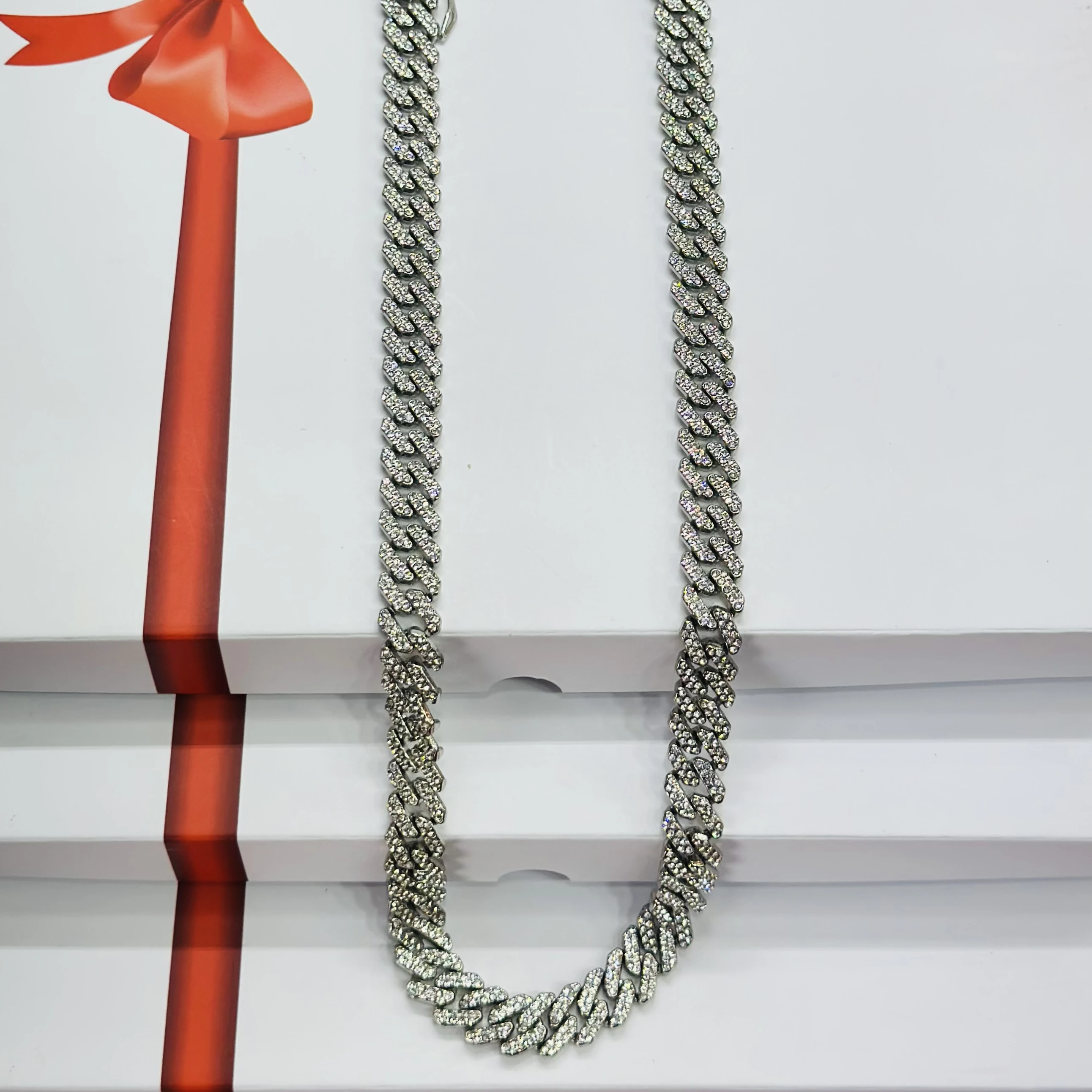 An iced-out silver-plated Cuban link chain necklace with cubic zirconia stones.