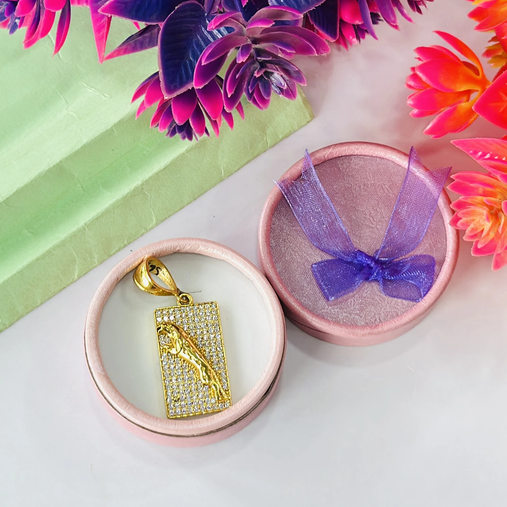 Gold plated jaguar pendant with a diamond texture background.