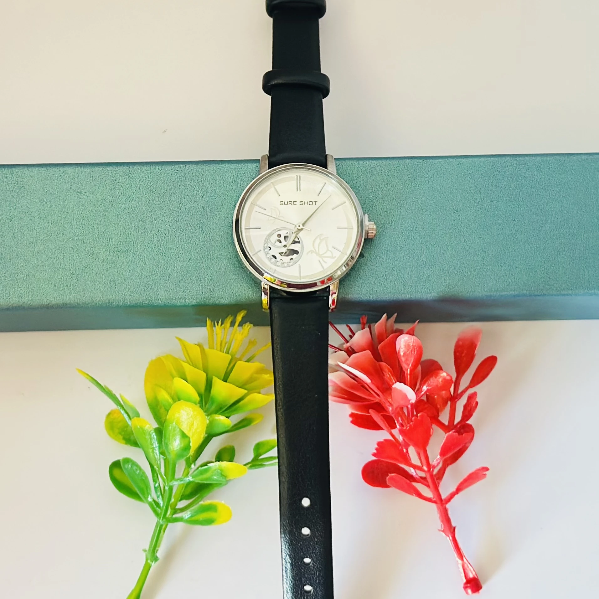 Sure Shot analog watch with a black leather band and silver-tone case.