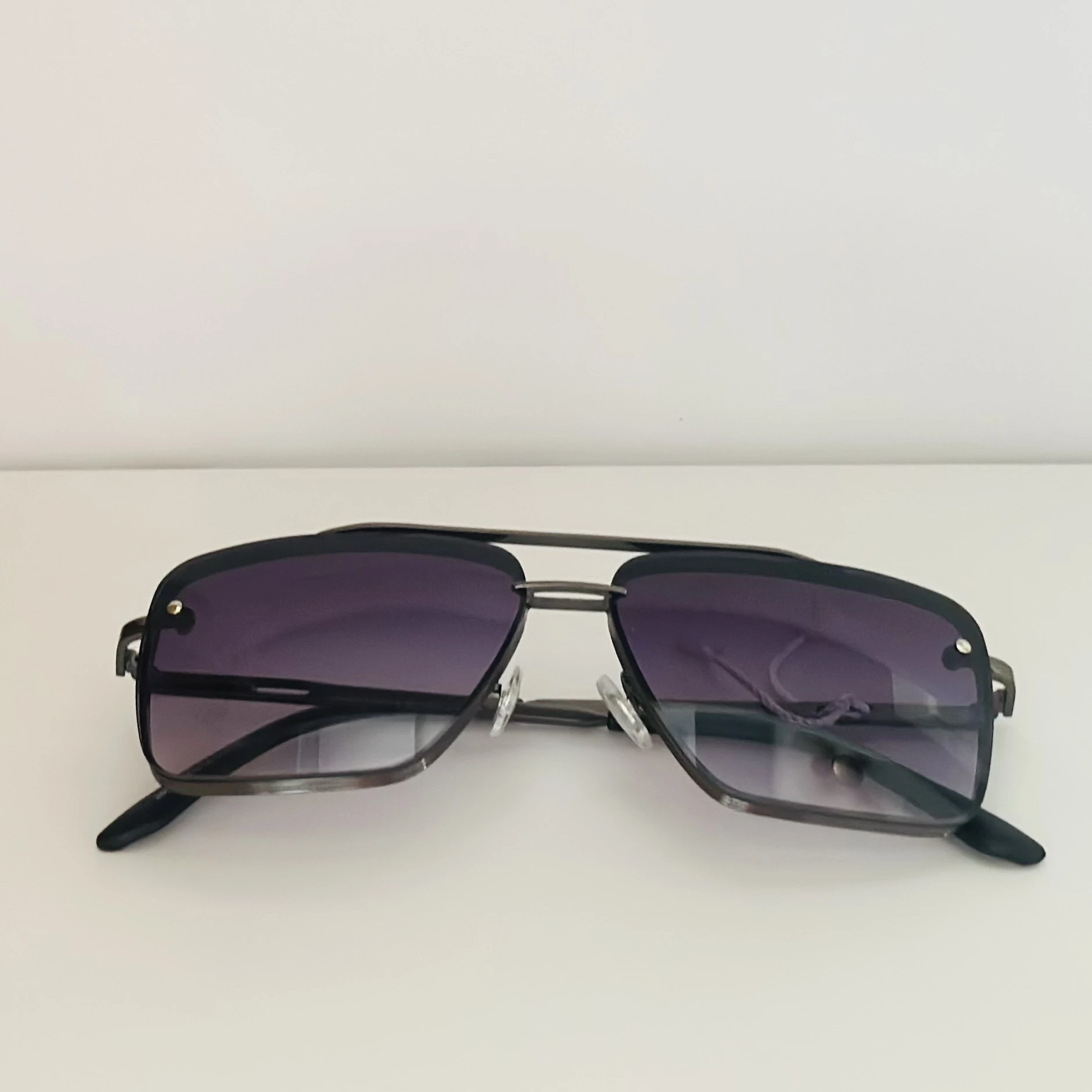 pair of modern big large square aviator sunglasses with a black metal frame and gradient lenses.