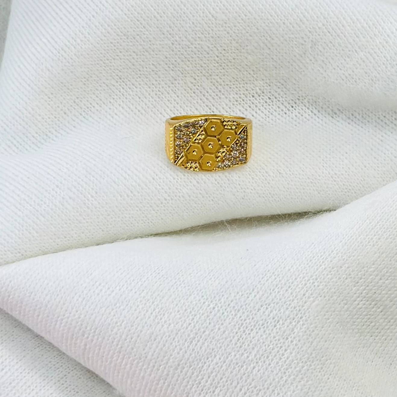 Gold men's ring with a hexagonal design and small white stones.