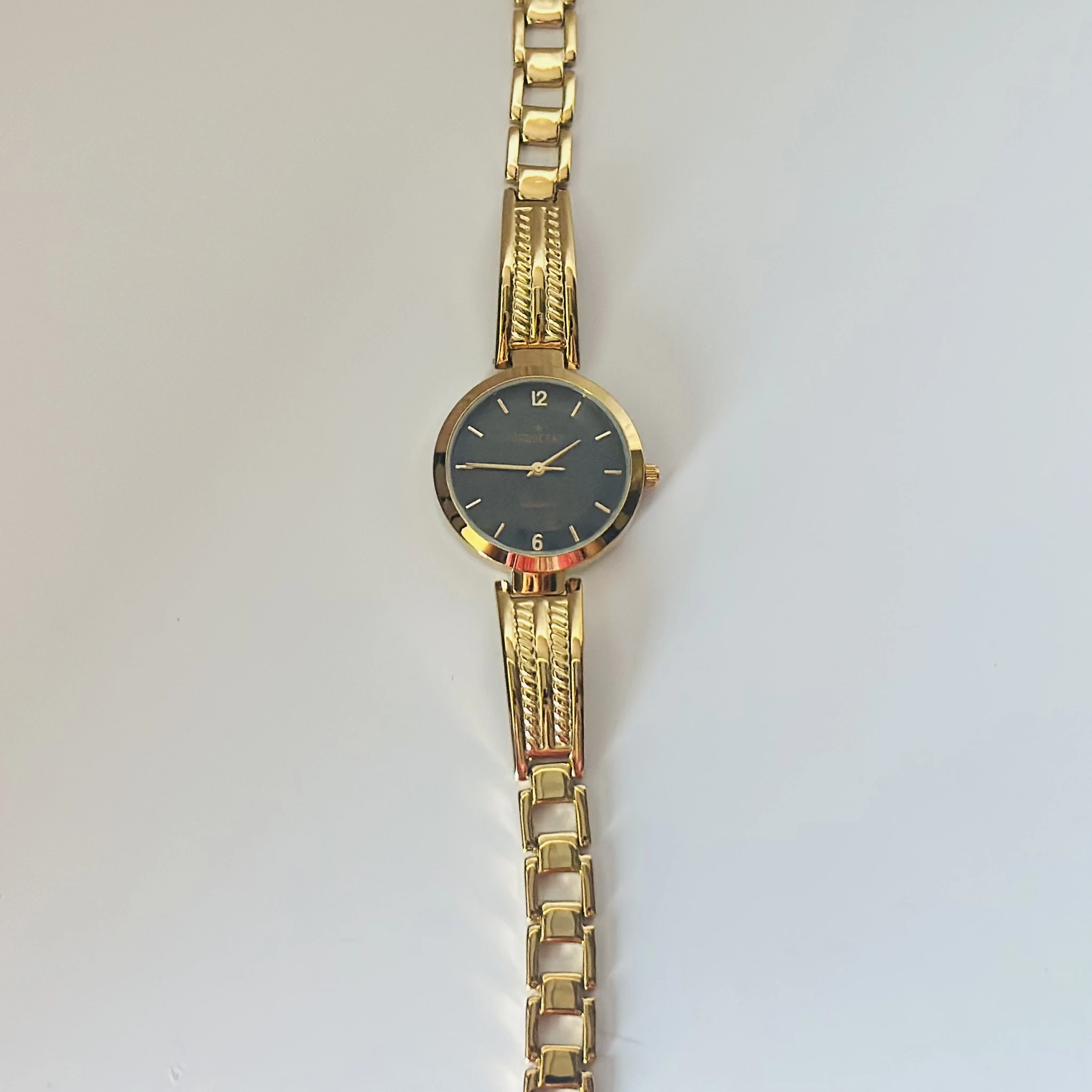 Anne Klein black dial gold-tone and black resin ladies watch.