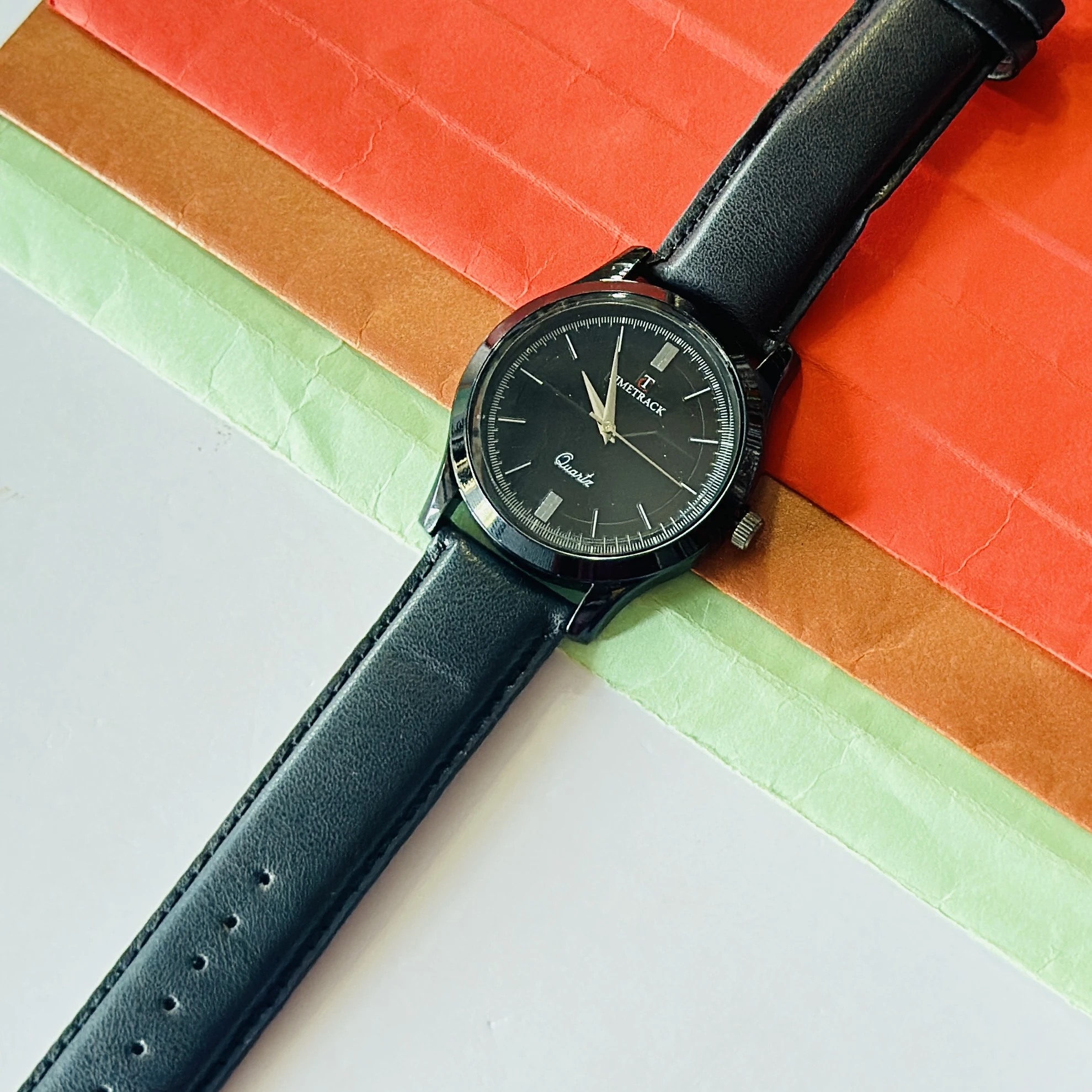 Timetrack Quartz wristwatch features a black analog dial and a black leather strap.
