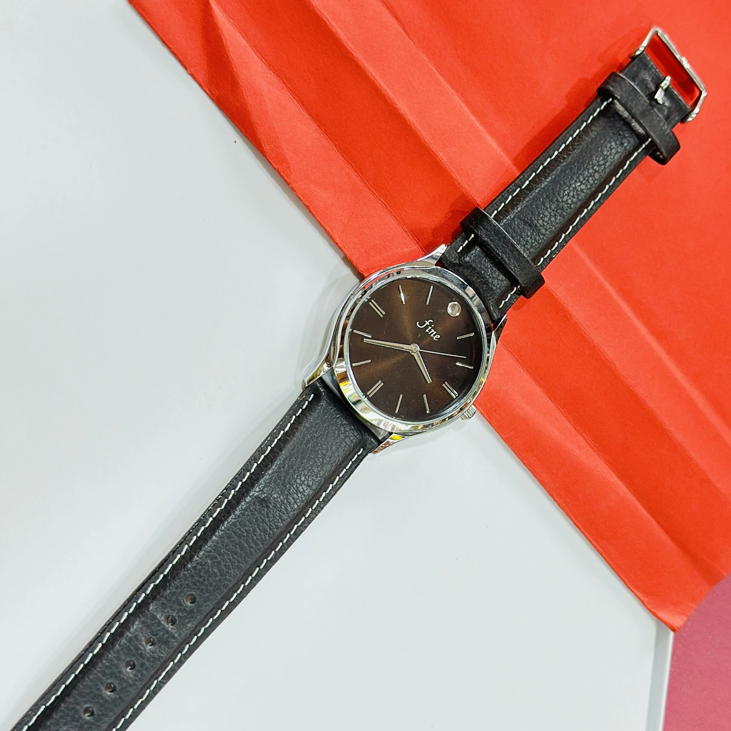 wristwatch featuring a black textured leather strap