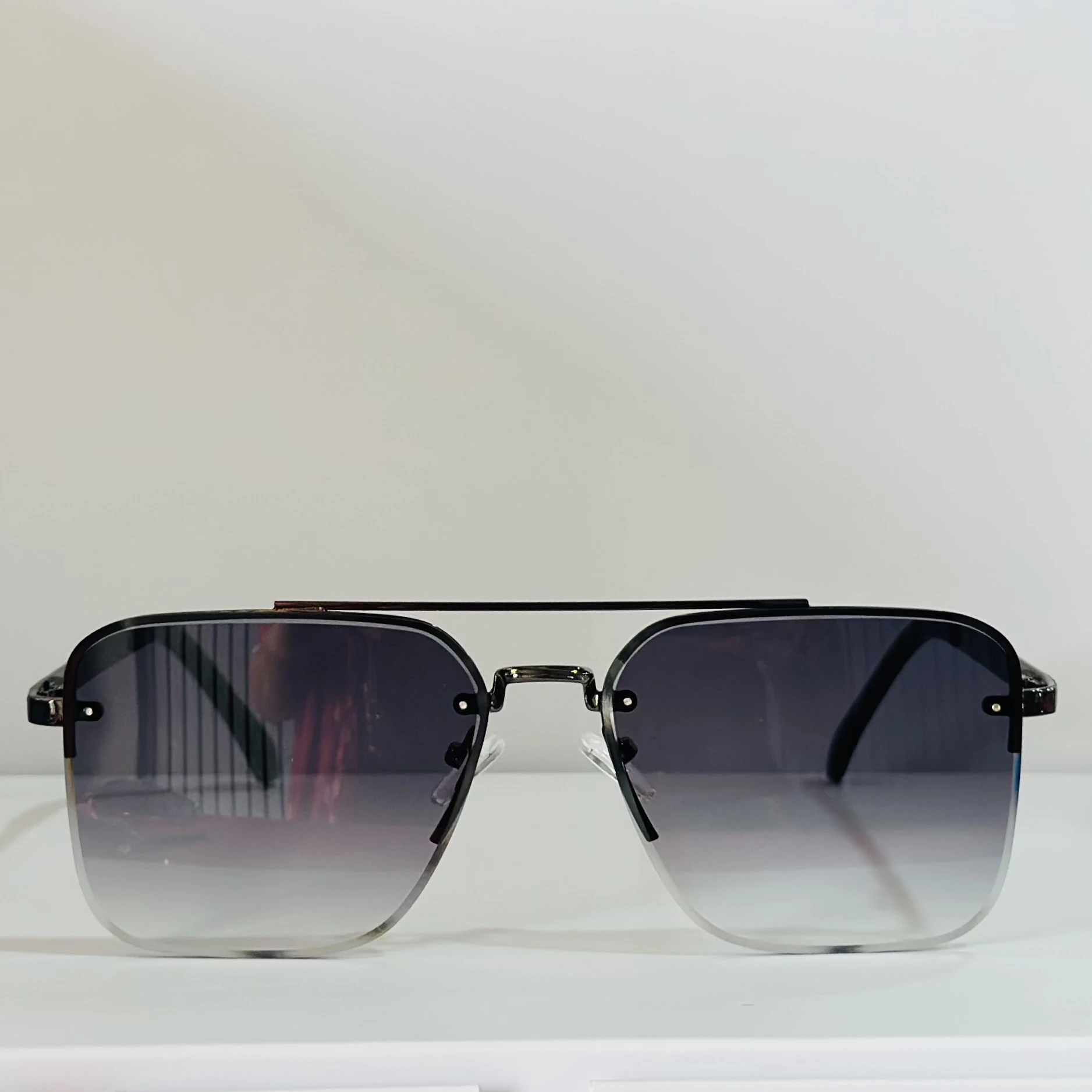 pair of aviator-style sunglasses with a black metal frame and grey gradient lenses.