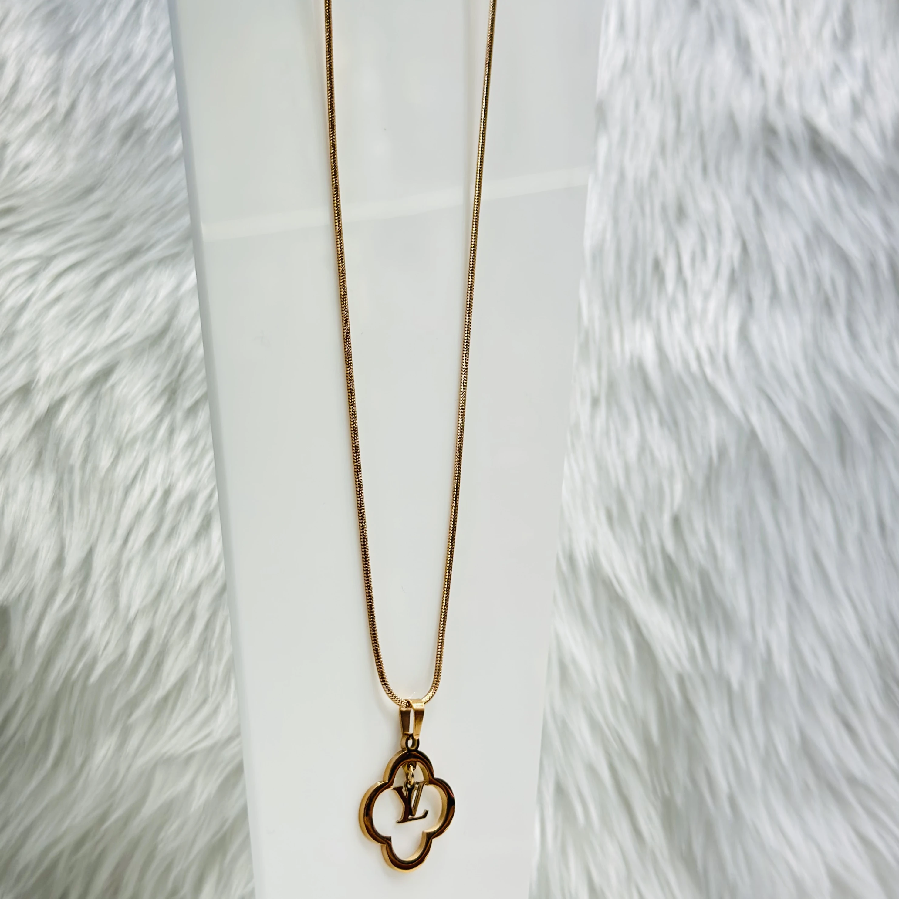 gold-plated pendant with a quatrefoil pendant featuring the 'LV' logo