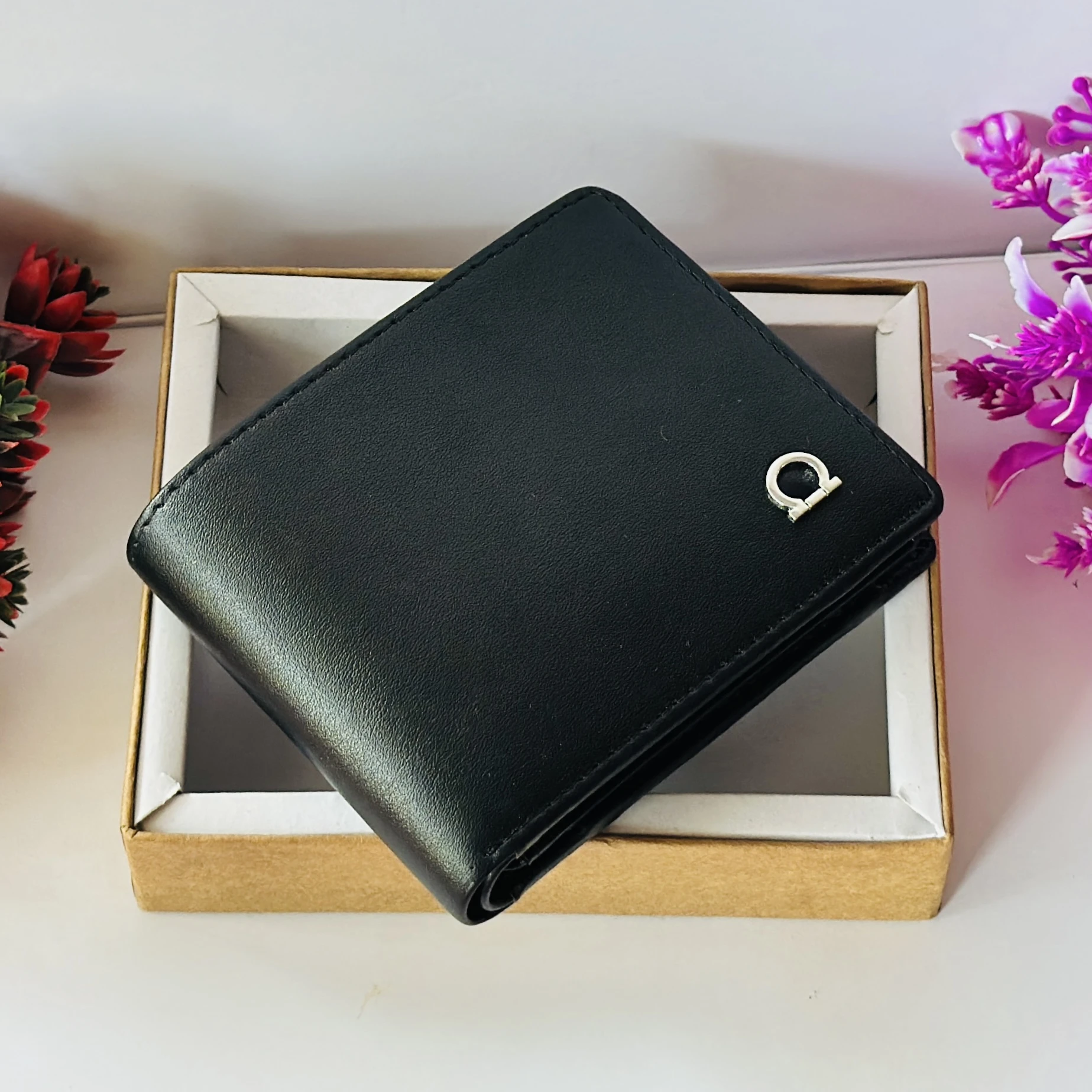 Ferragamo Gancini bi-fold wallet in black calf leather.