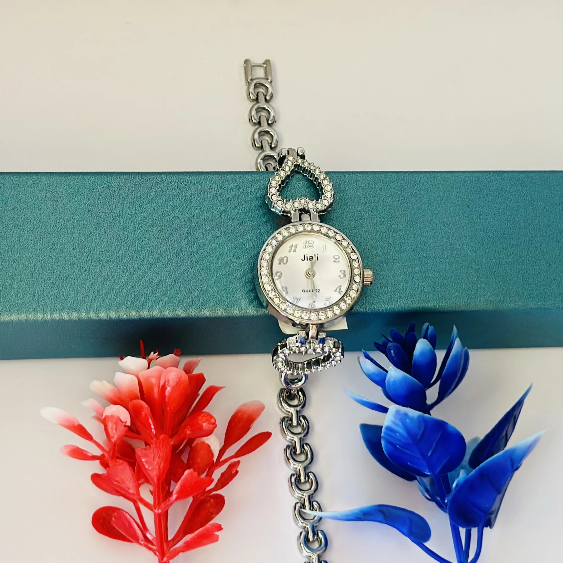Women’s watch with a silver metal bracelet and crystal-studded bezel.