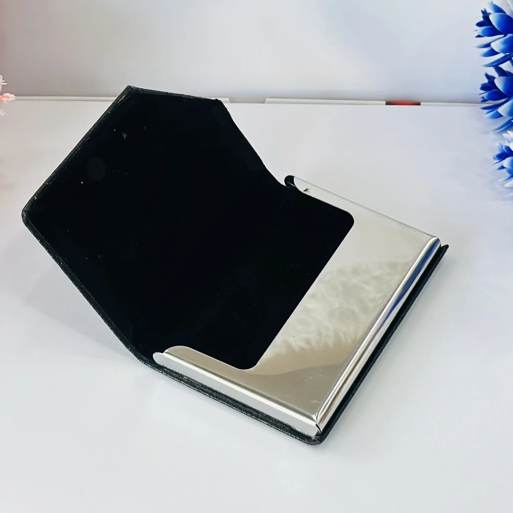 Black faux leather and metal business card holder.