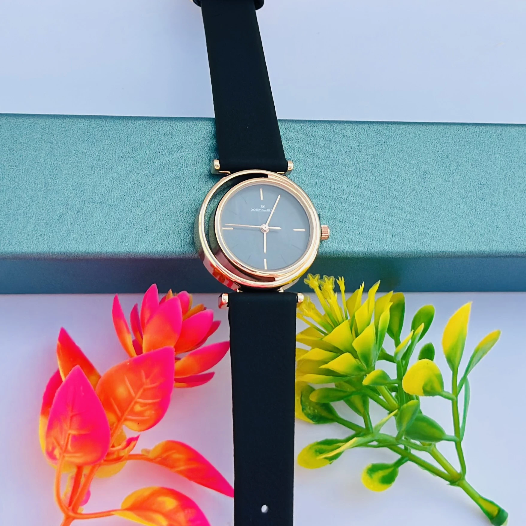 Analog with Pink Dial watch for women with a black plastic strap.