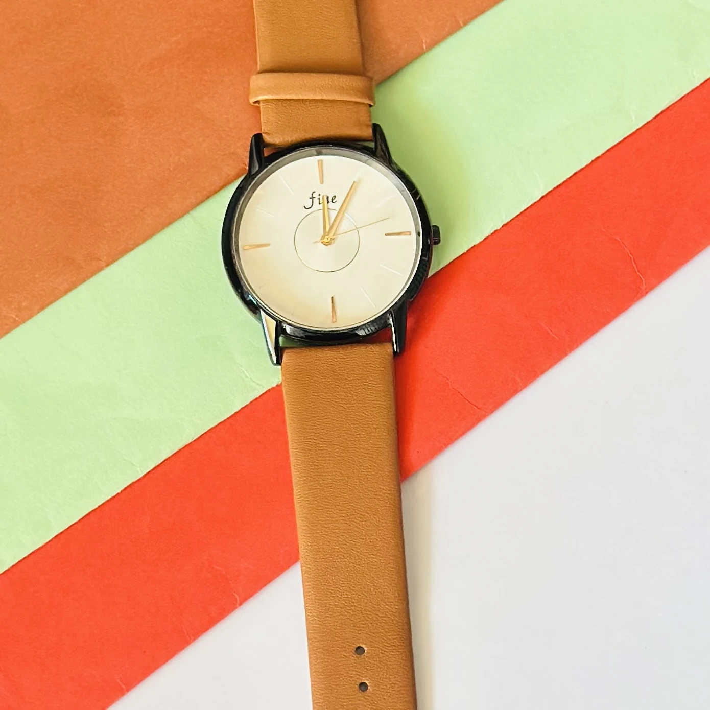 Analog wrist watch with a brown leather strap.