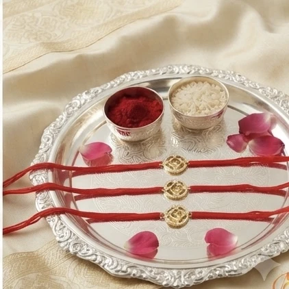 Silver Om-themed rakhis, featuring gold plating and stone studding.