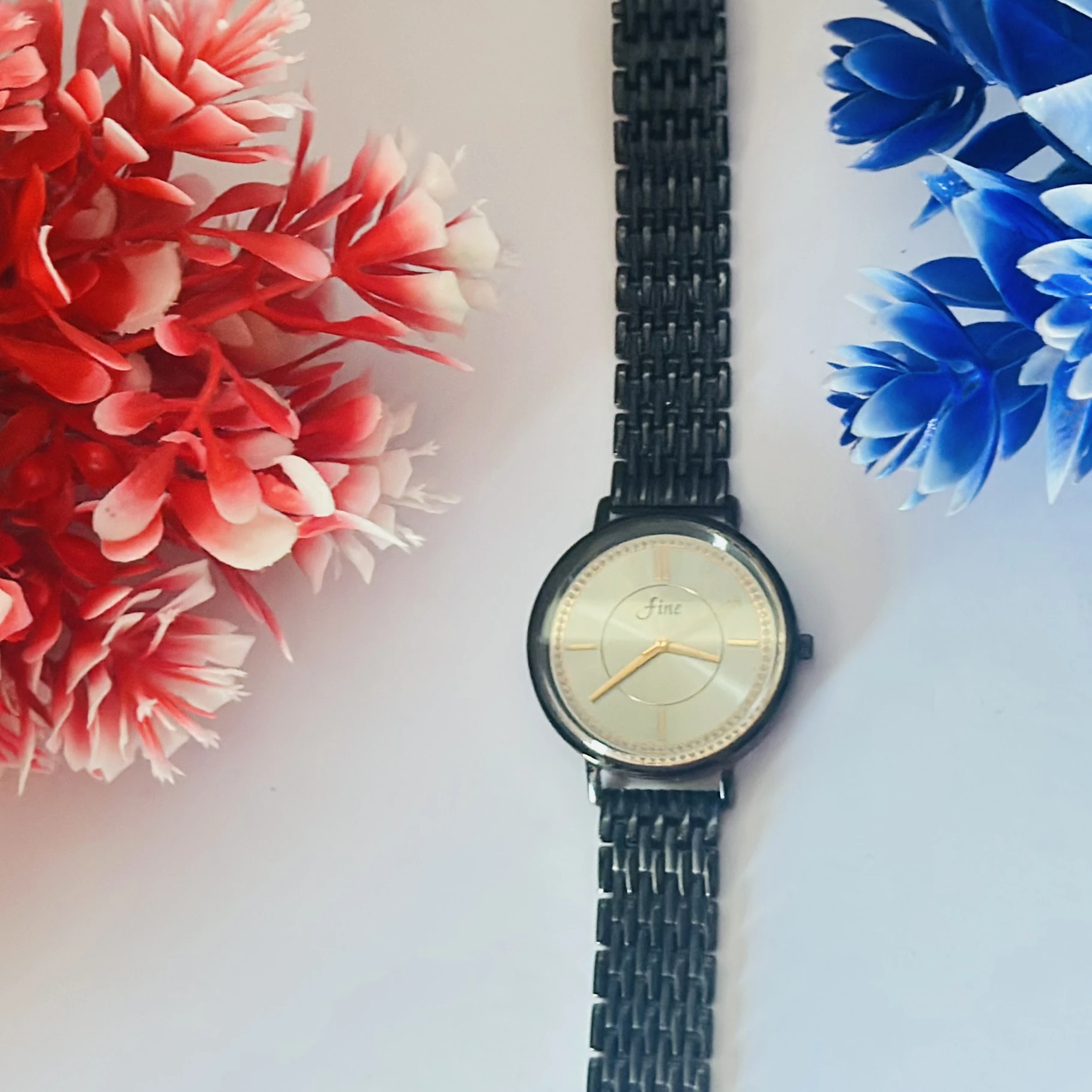 Black metal analogue women's watch with a silver dial.