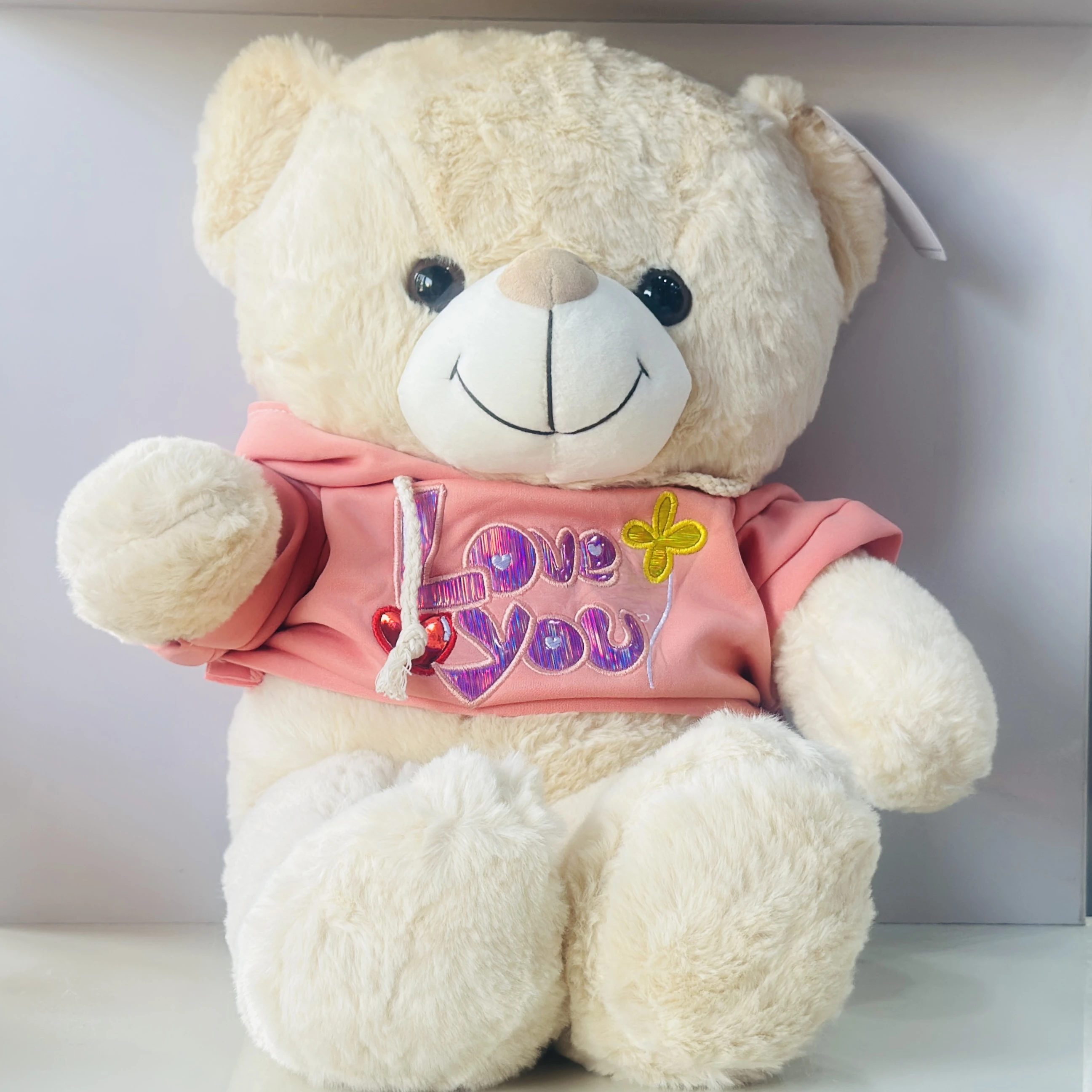 soft plush teddy bear toy wearing a pink hoodie with "I Love You" text.