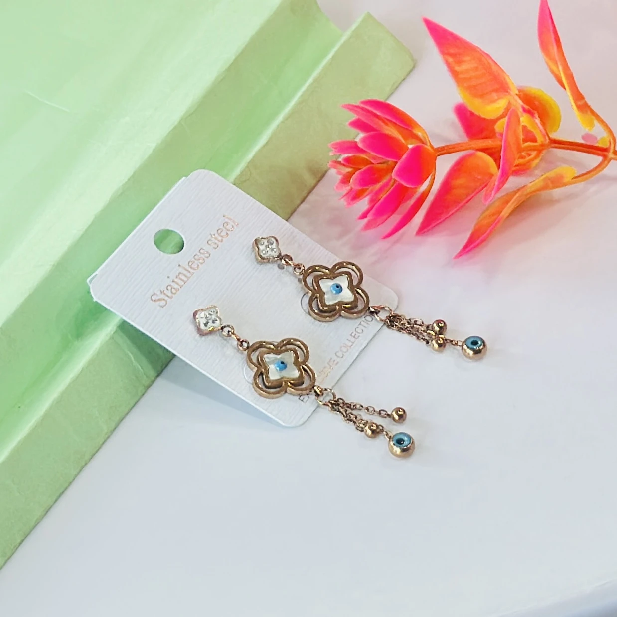 Rose gold-toned, stainless steel flower and evil eye drop earrings.