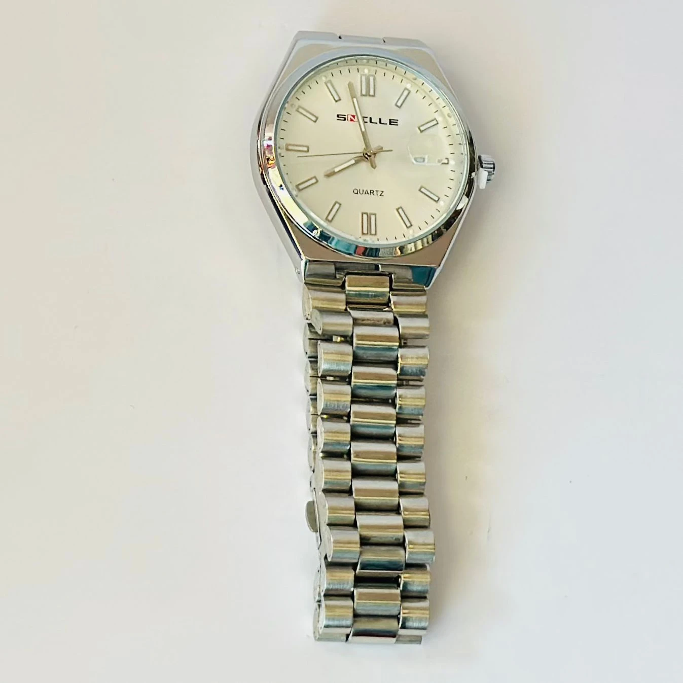 Snille analog quartz watch with a white dial and silver stainless steel strap.