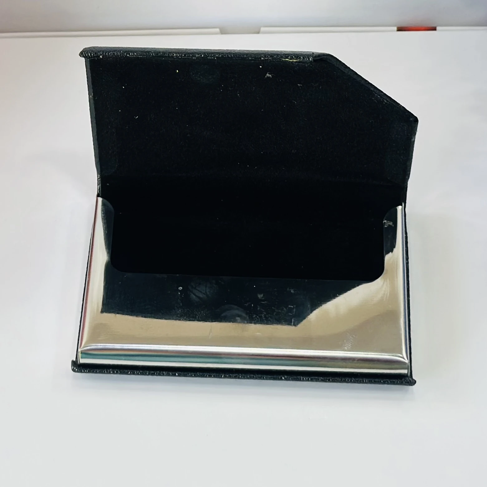 Black faux leather and metal business card holder.