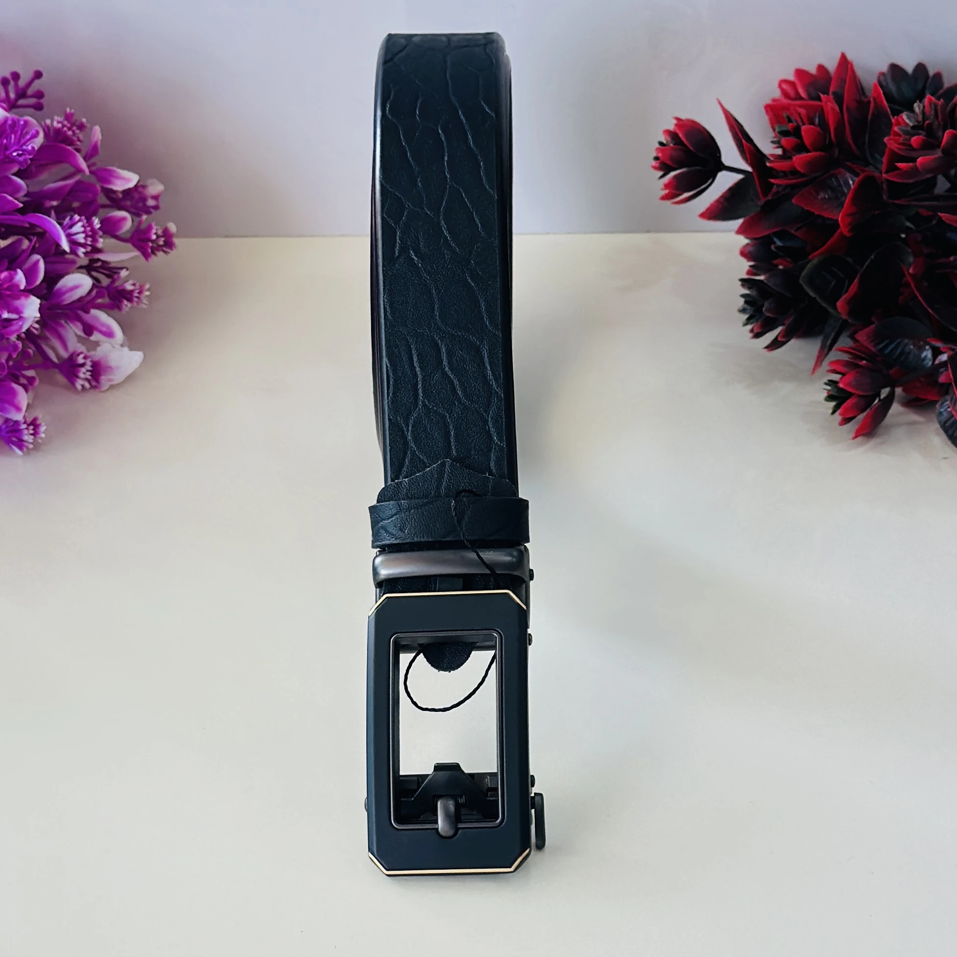 Black leather belt with a metal plaque buckle.