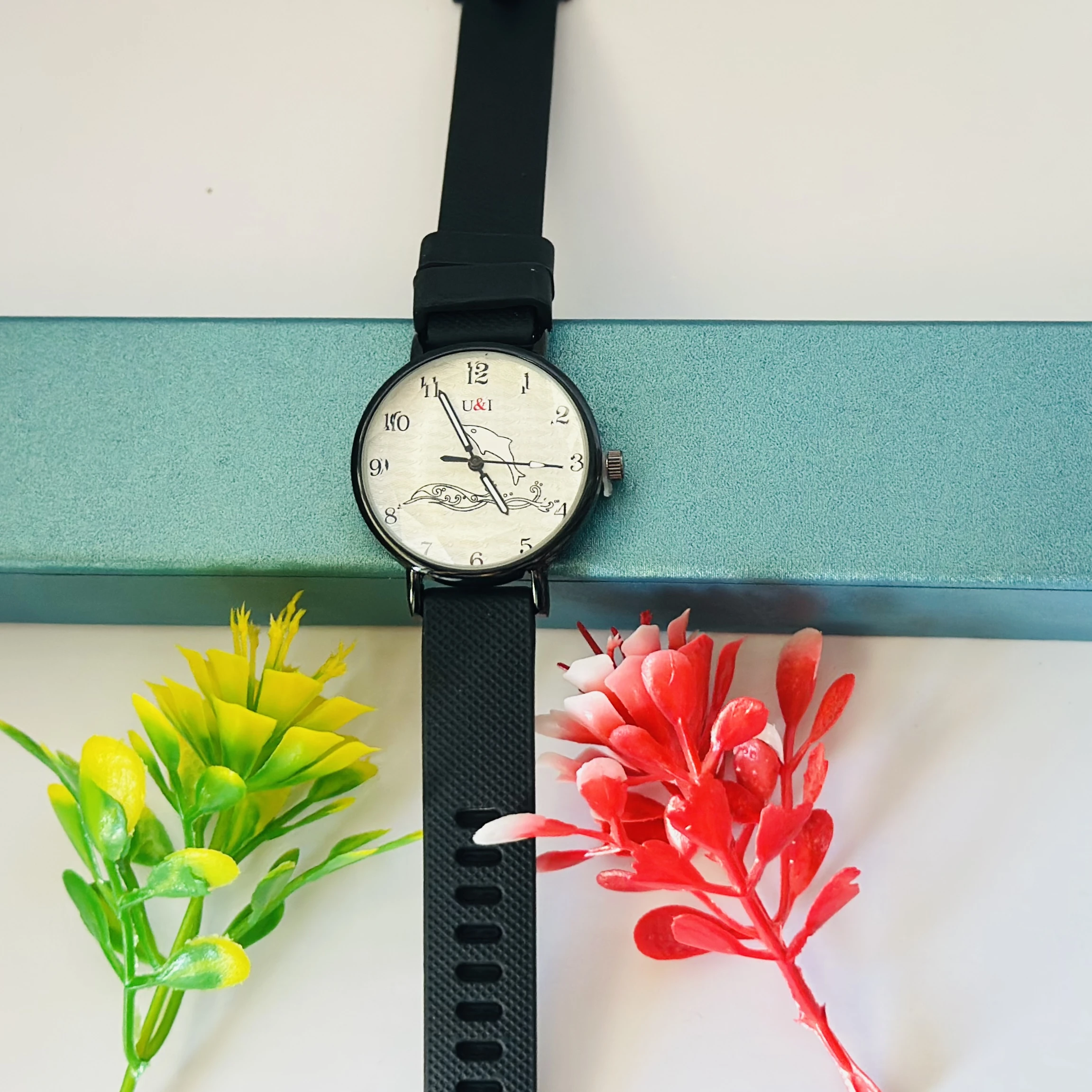 Analog wrist watch with a black rubber strap