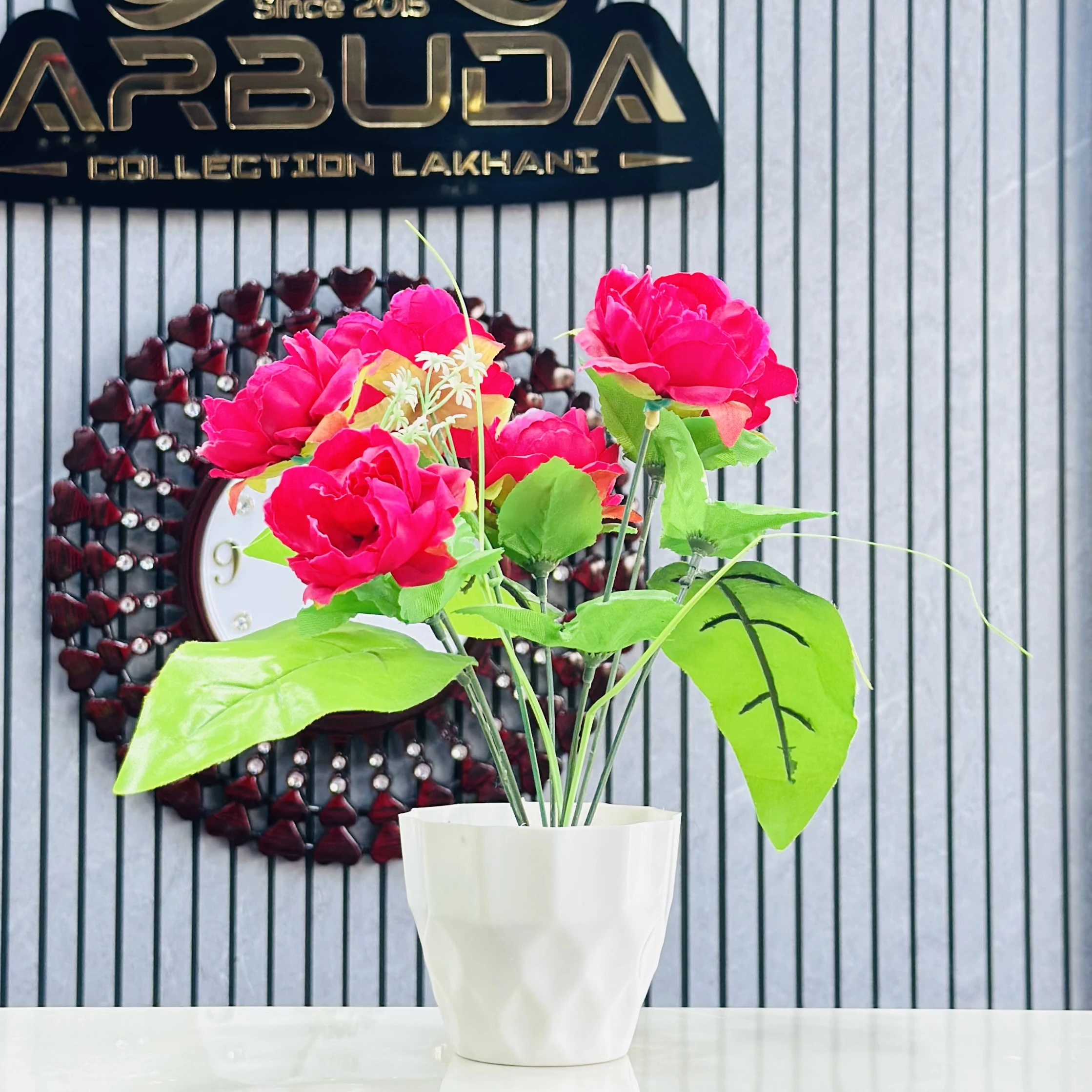 Red rose flower arrangement in a white pot.