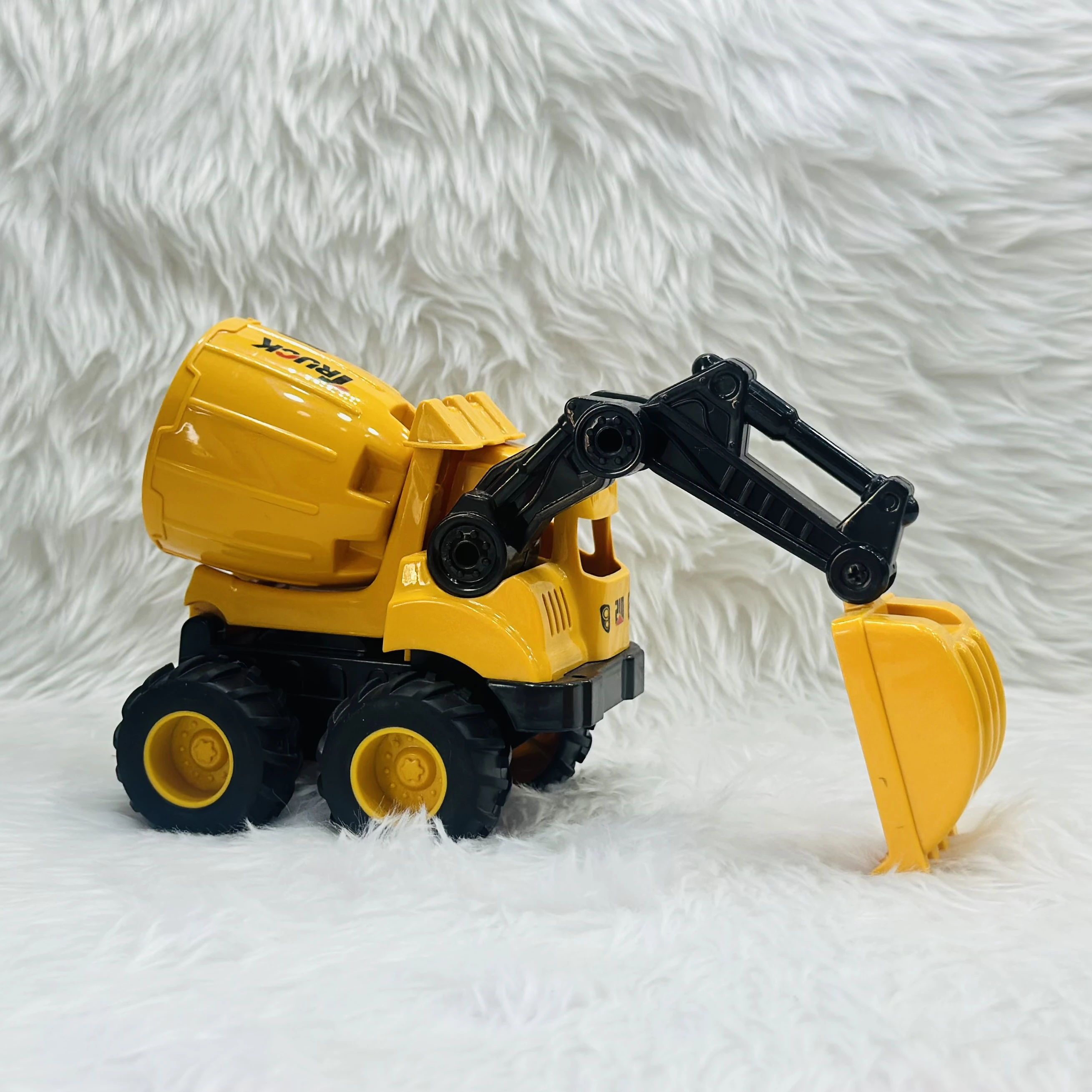 Cement mixer with an attached excavator arm.