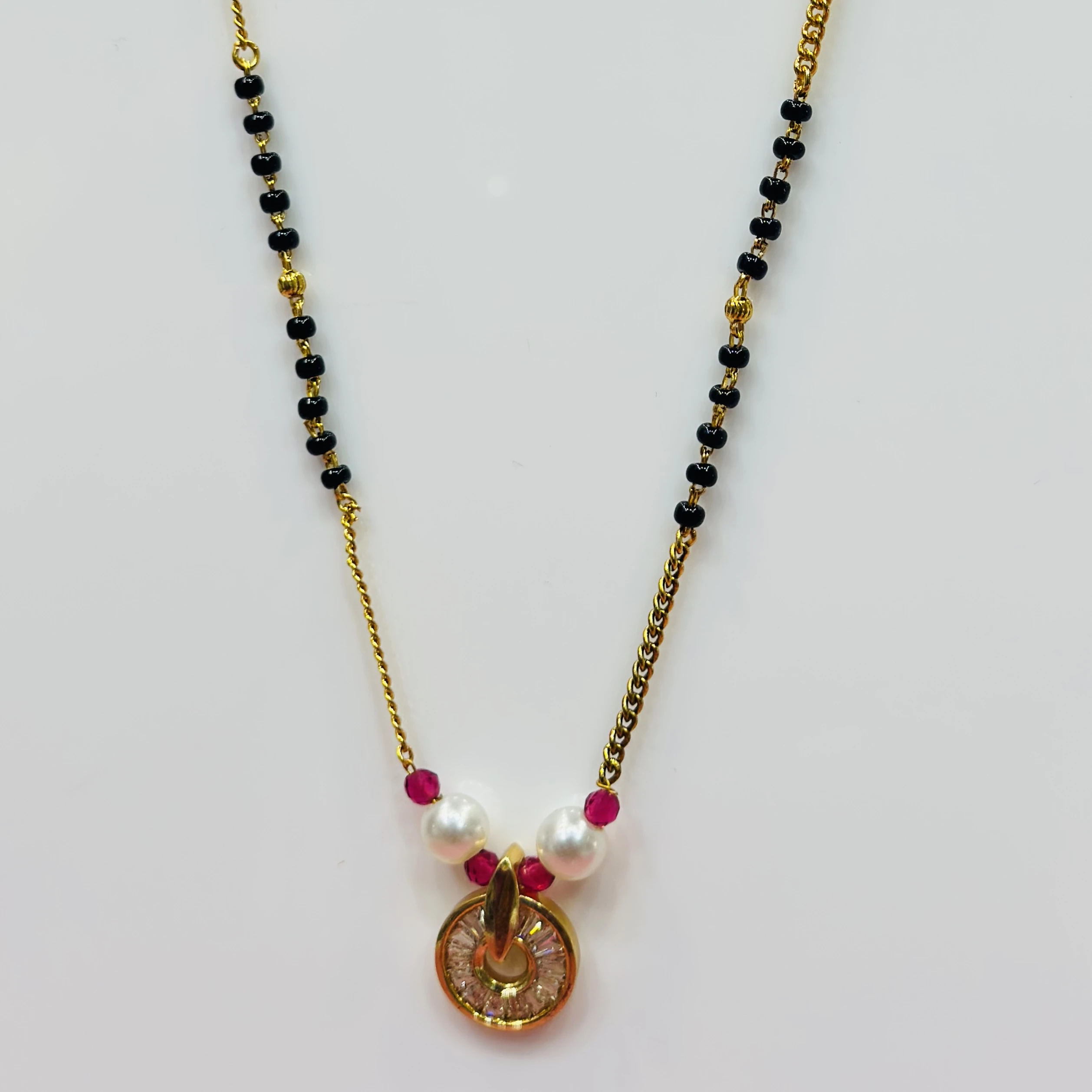 gold-plated cubic zirconia and pearl mangalsutra with red accents.