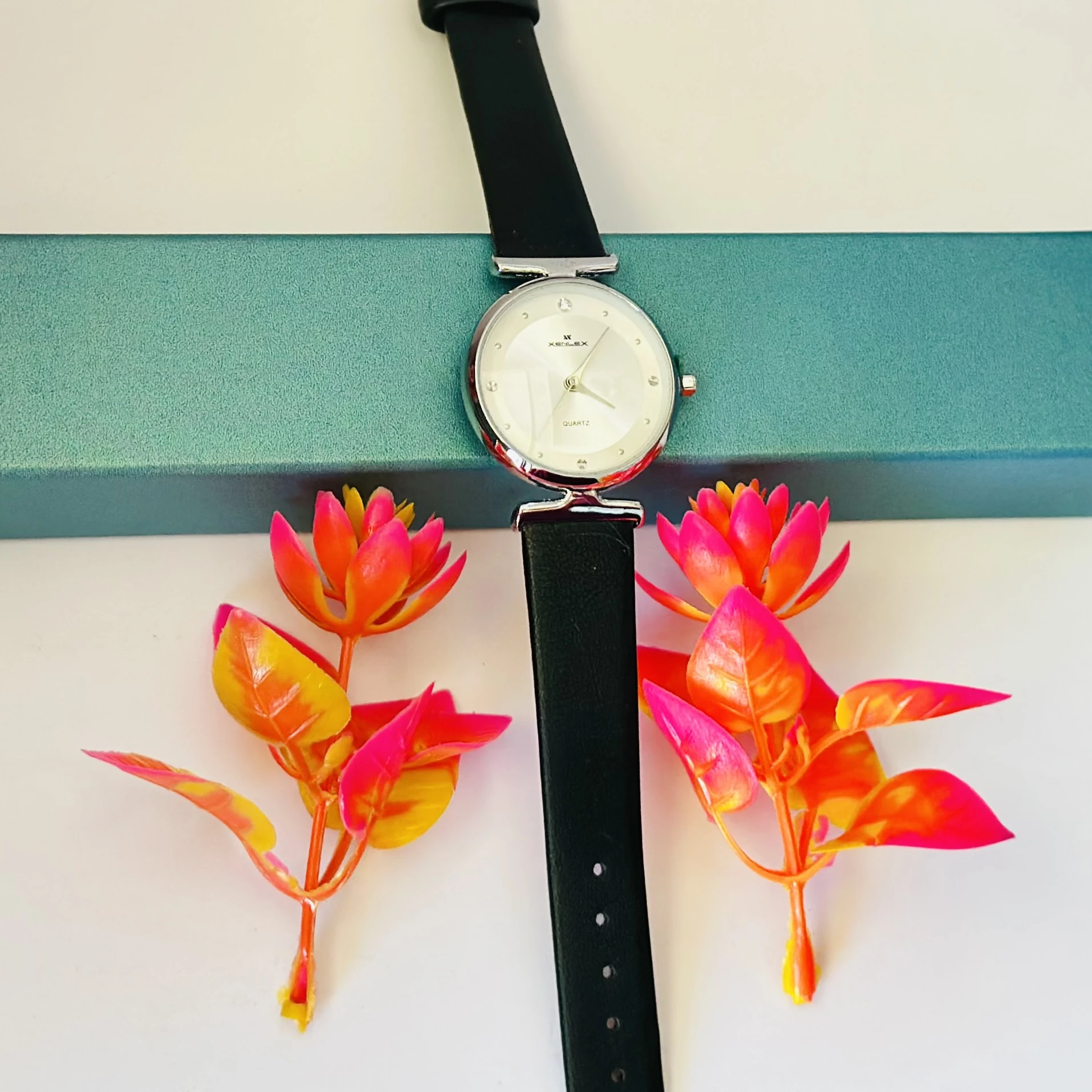 Analogue watch for women with a black leather strap.