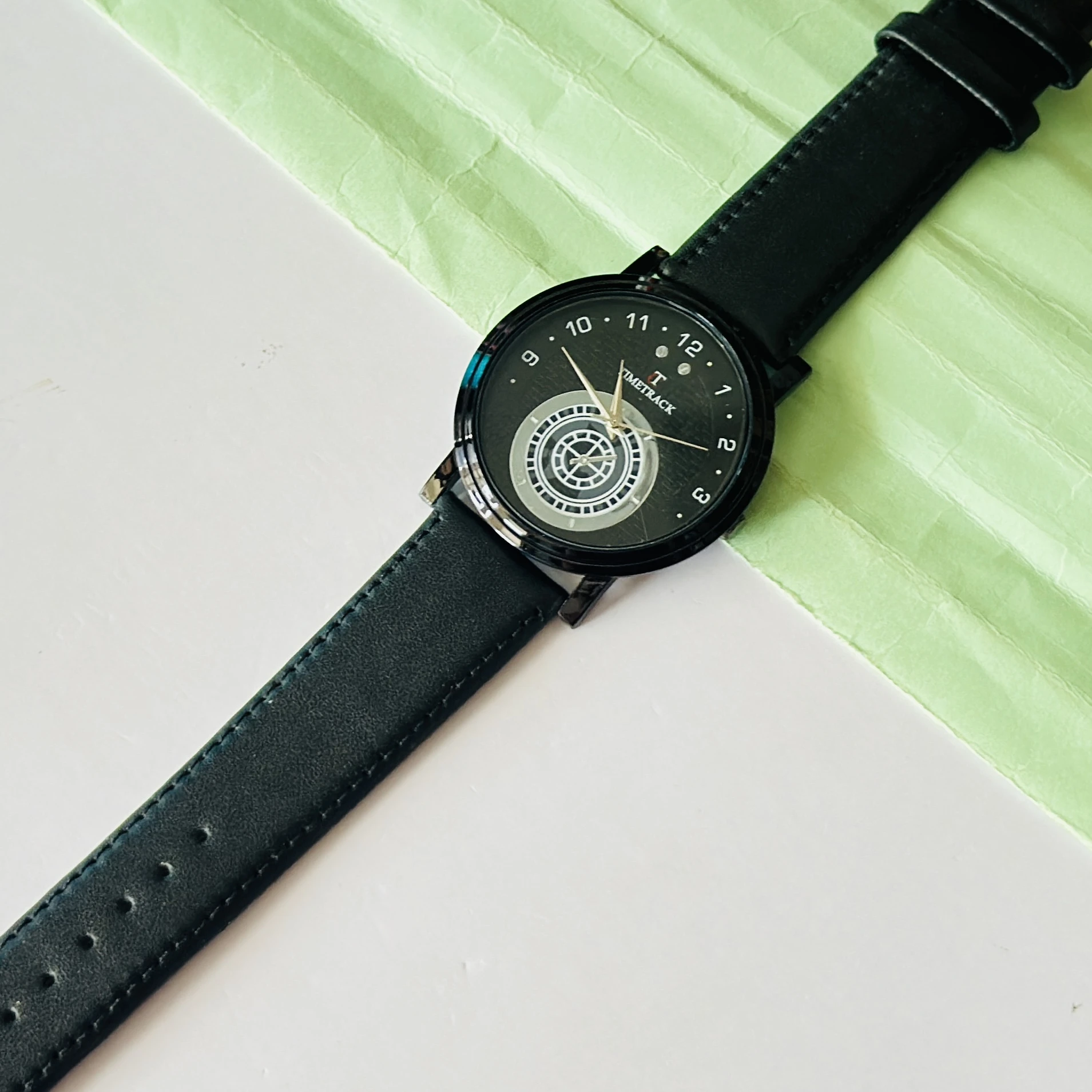 Timetrack quartz analog watch with a black leather strap and a distinctive patterned dial