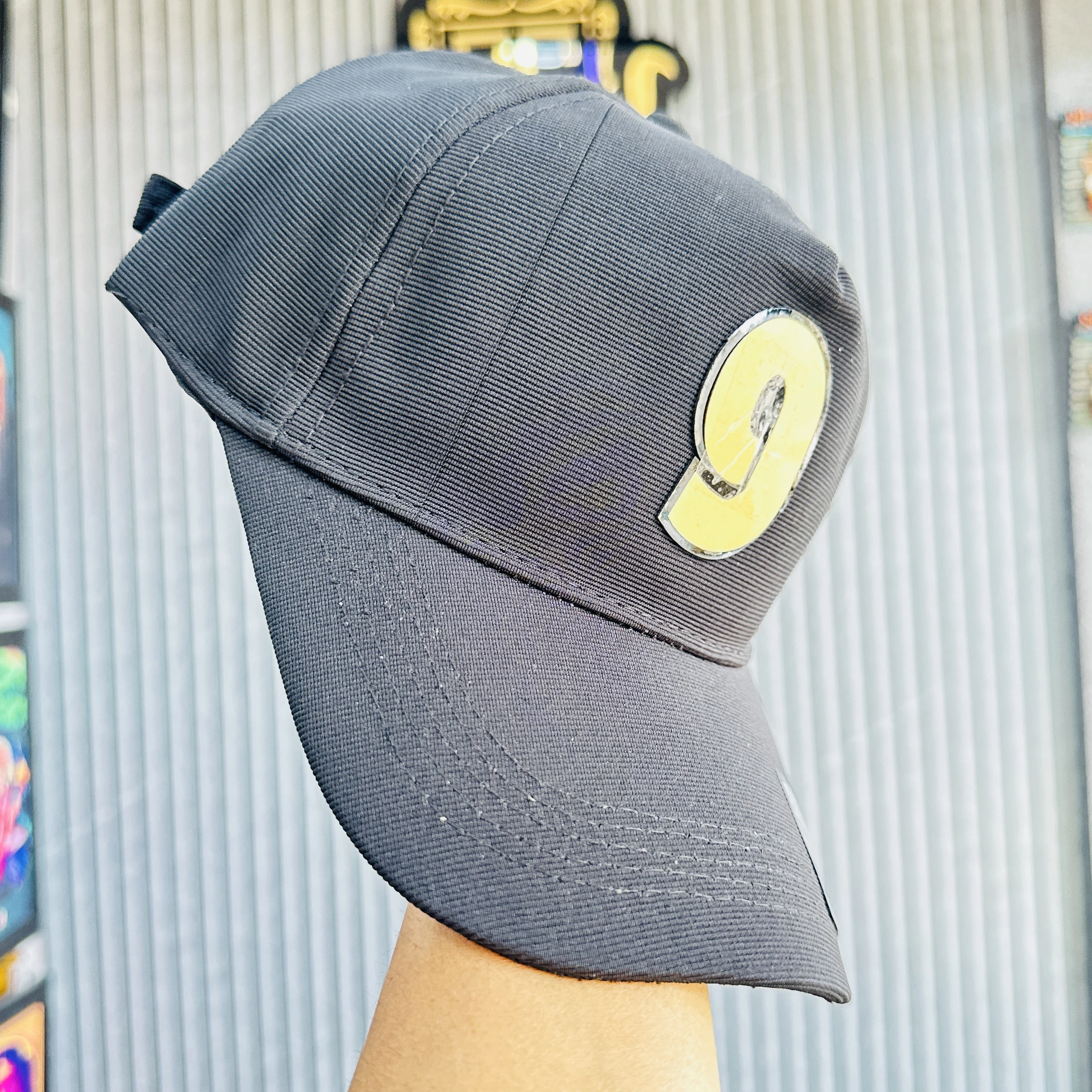 cap features a prominent yellow and black number '9' patch on the front.