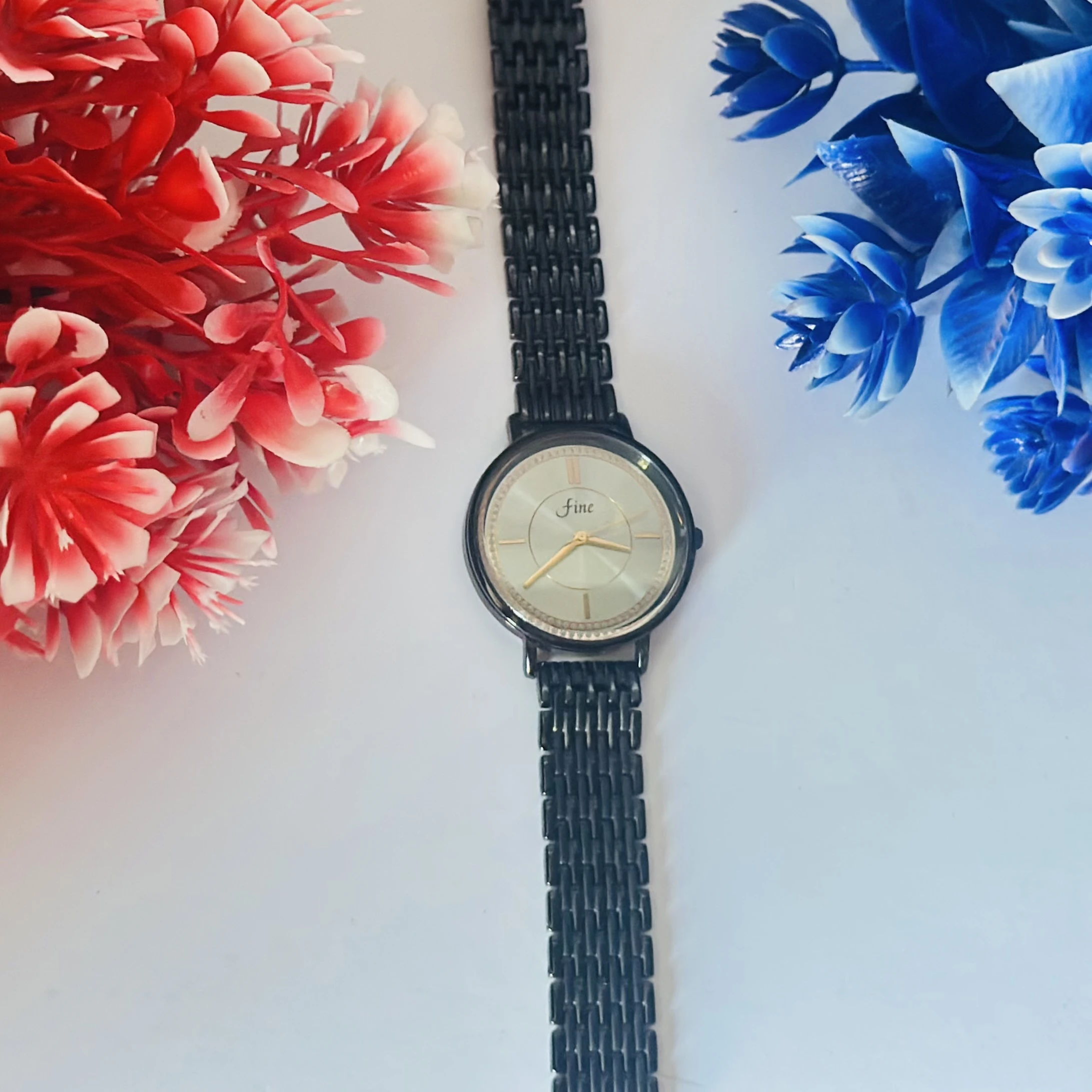 Black metal analogue women's watch with a silver dial.