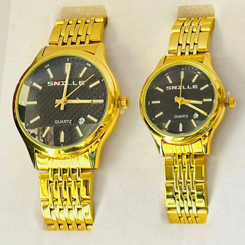pair of Snille Date Series analog quartz watches for men and women with gold-tone link bracelets and black dials.