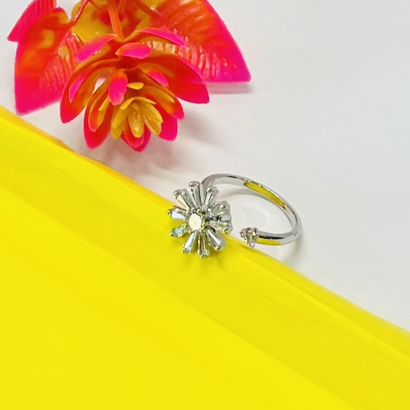 silver-plated cubic zirconia studded floral or starburst finger ring.