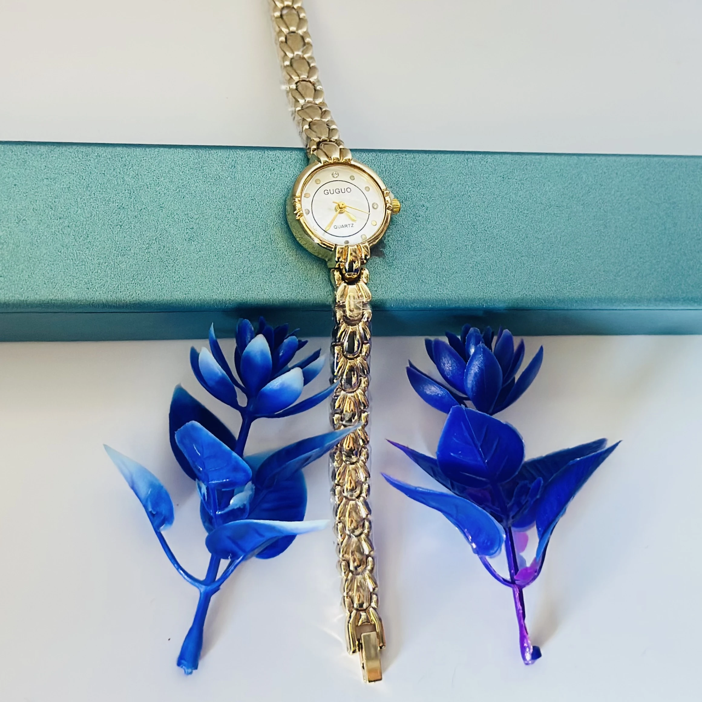 gold-tone GUGUO quartz choker watch with a round white face.