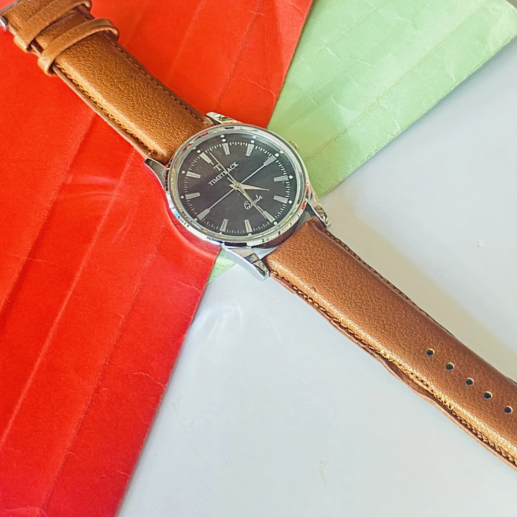 analog watch with a brown leather strap and a silver-toned case.
