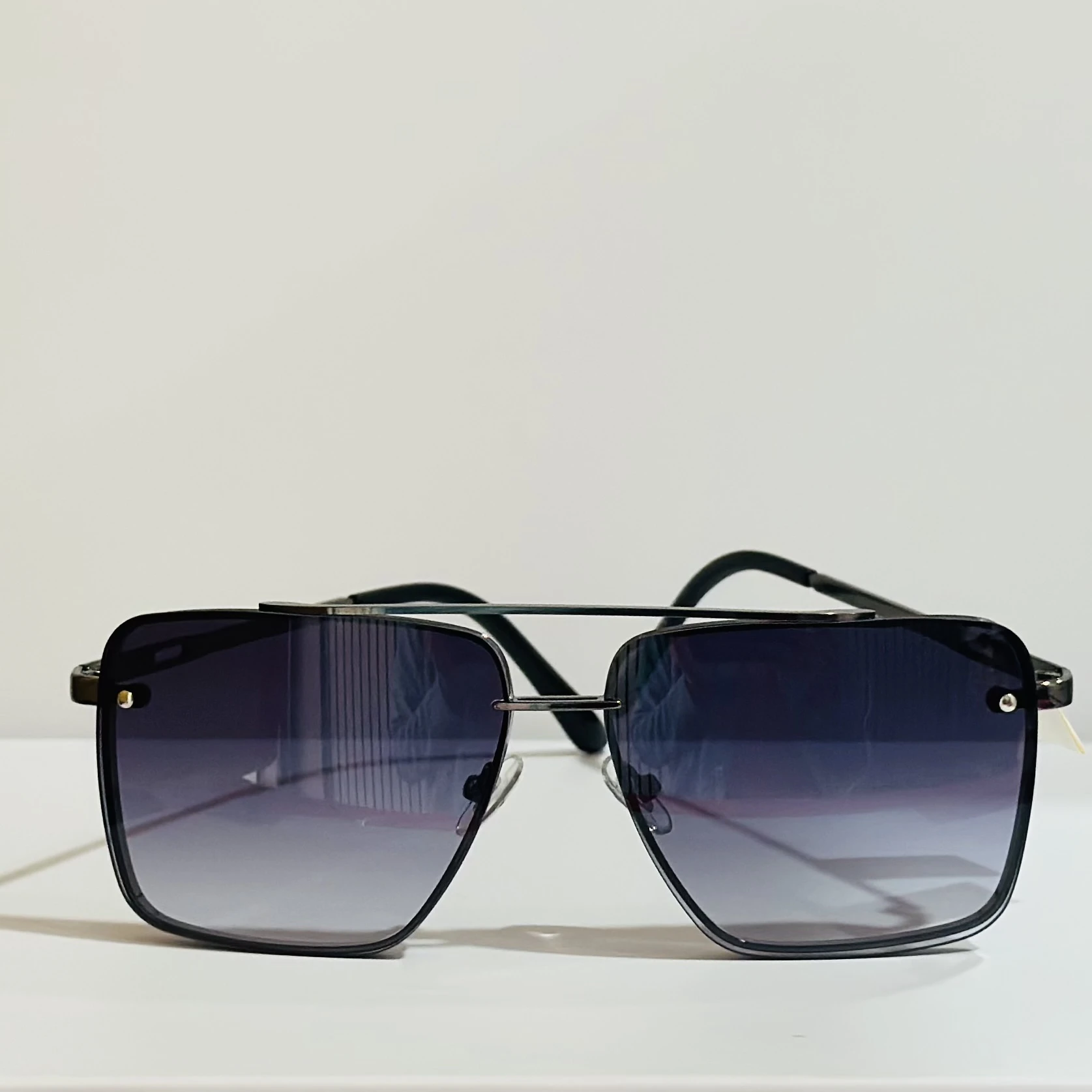 pair of square aviator sunglasses with a black metal frame and gradient lenses.