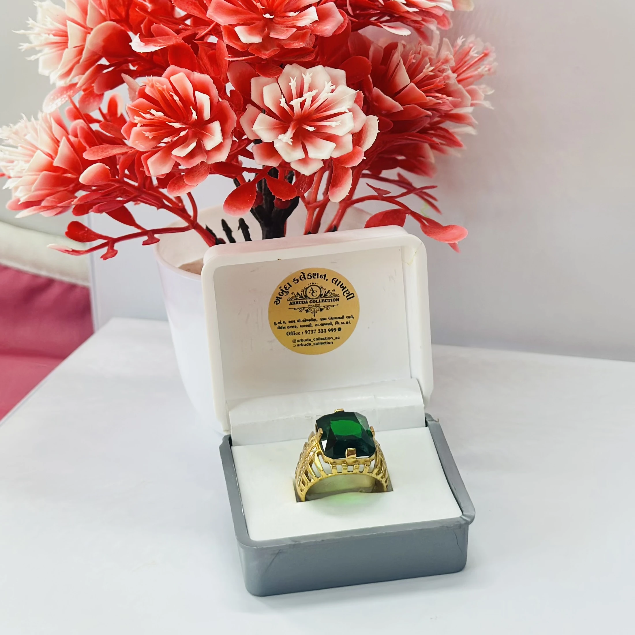 Gold plated men's ring with a green artificial stone and white artificial diamonds.