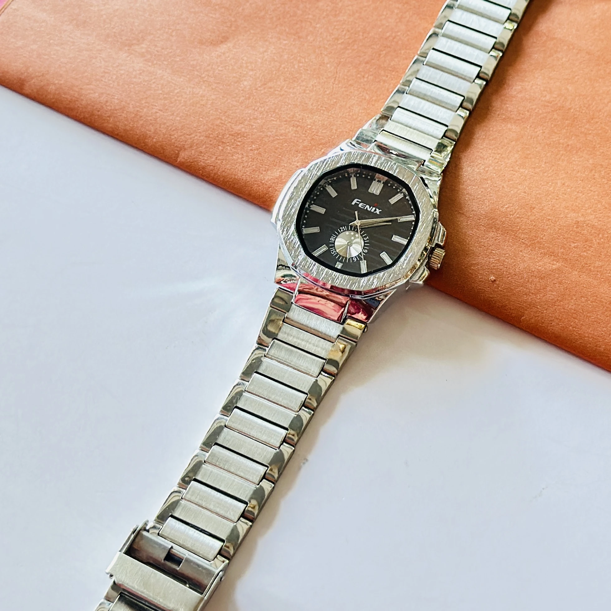 Fenix analog watch featuring a silver-tone stainless steel strap and a black dial.
