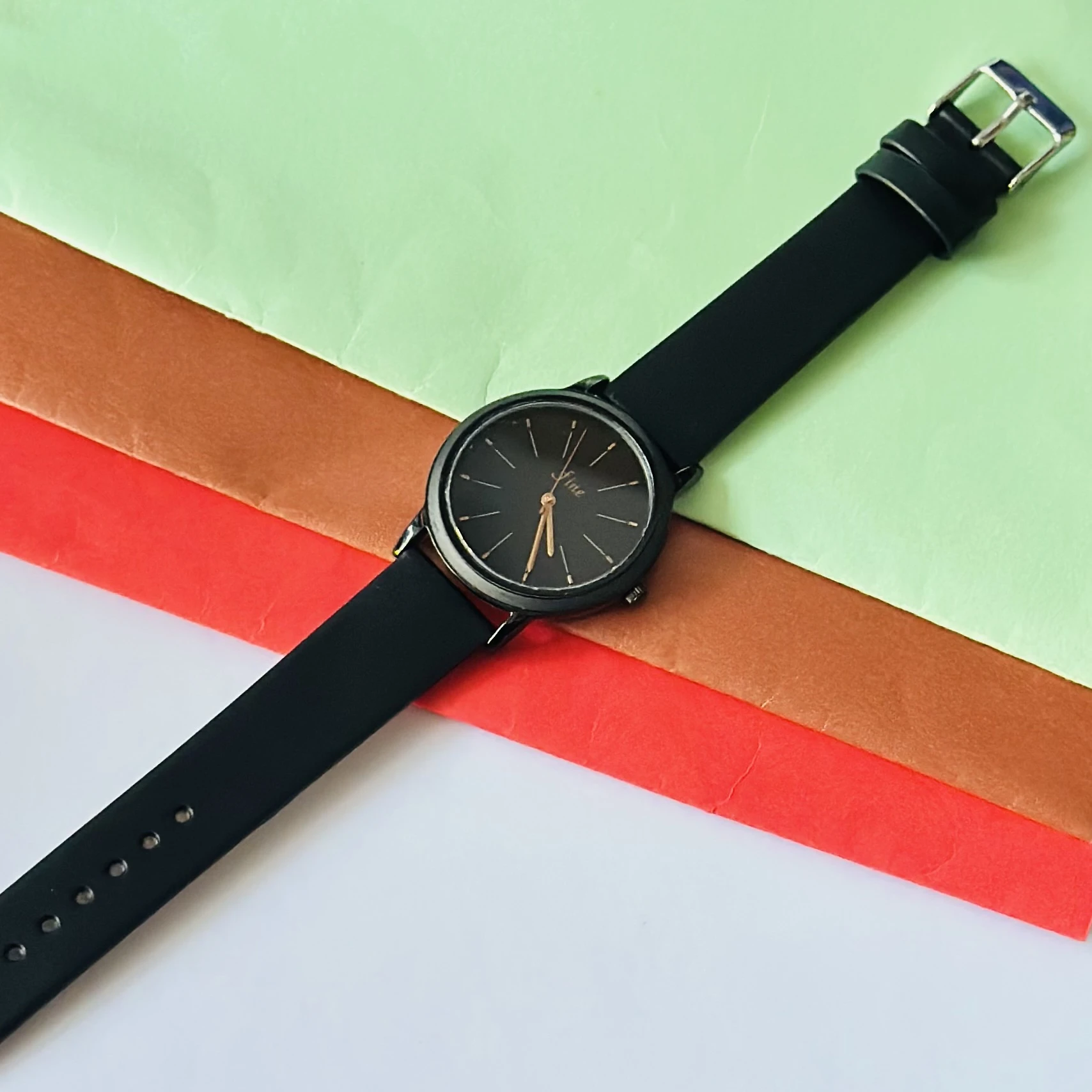 women's analog watch in black with a silicone strap.