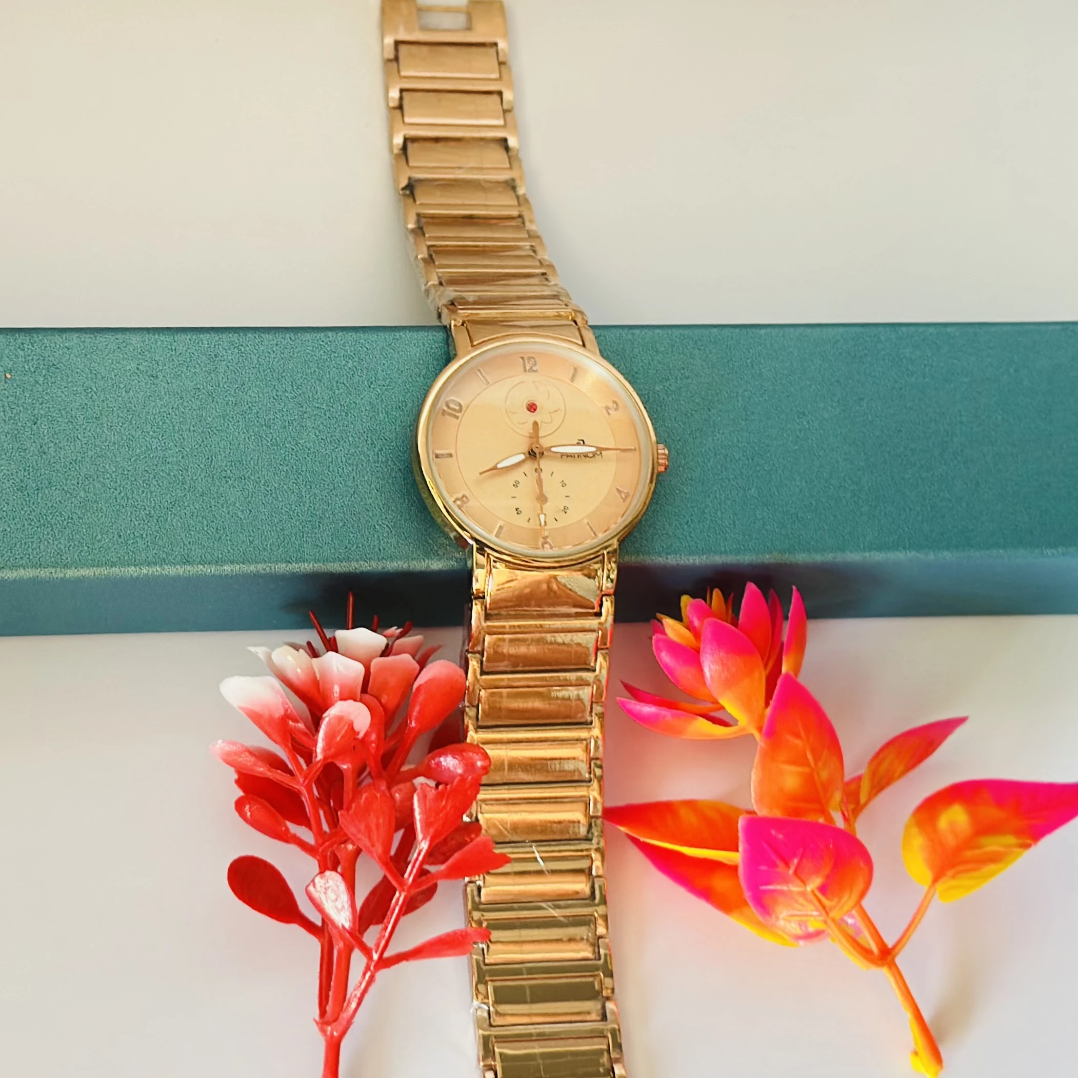 Gold -tone women's analog watch with a metal link bracelet.