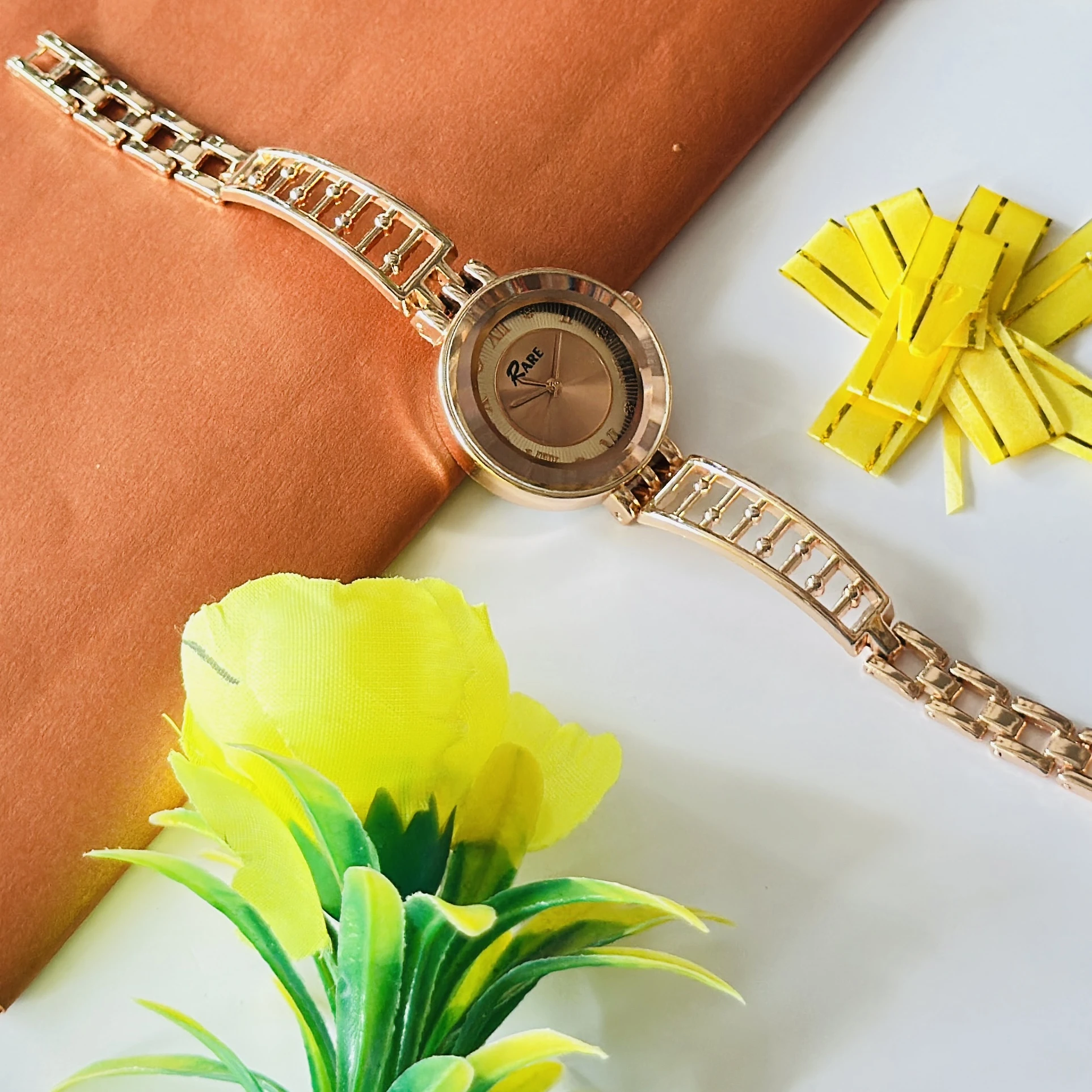 Raga women's rose gold analog wristwatch with a unique bracelet design
