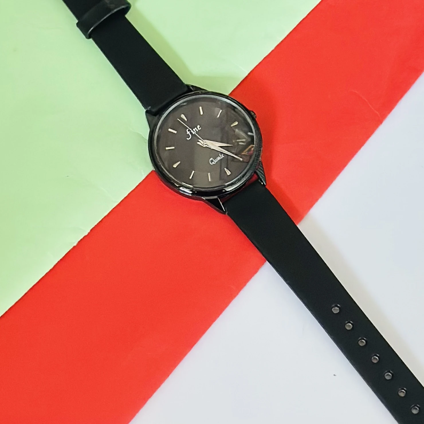 Black analog quartz wrist watch with a black strap.