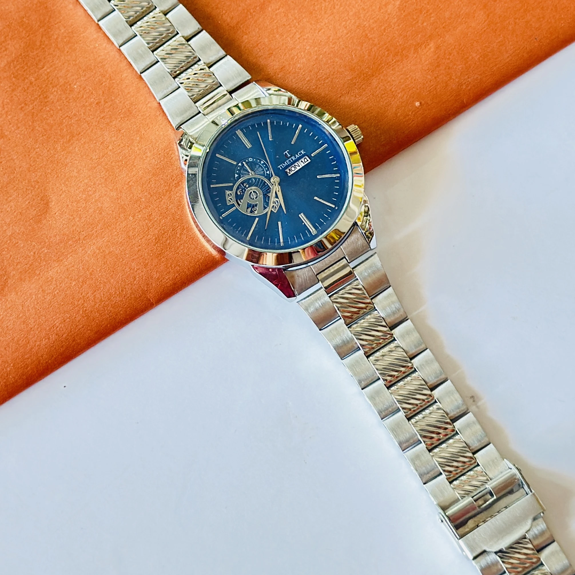 Timetrack stainless steel automatic watch with a blue dial and a bracelet strap.