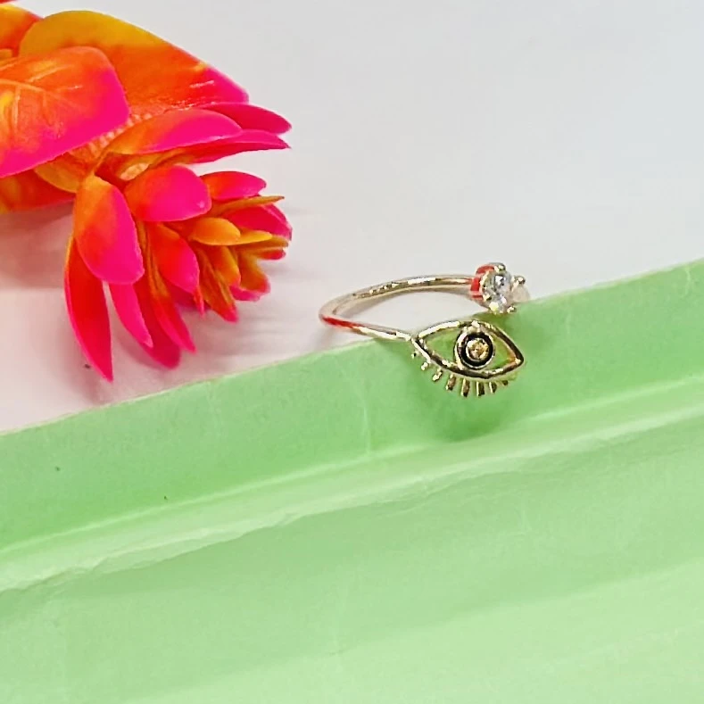 An adjustable gold-toned evil eye ring featuring a cubic zirconia accent.