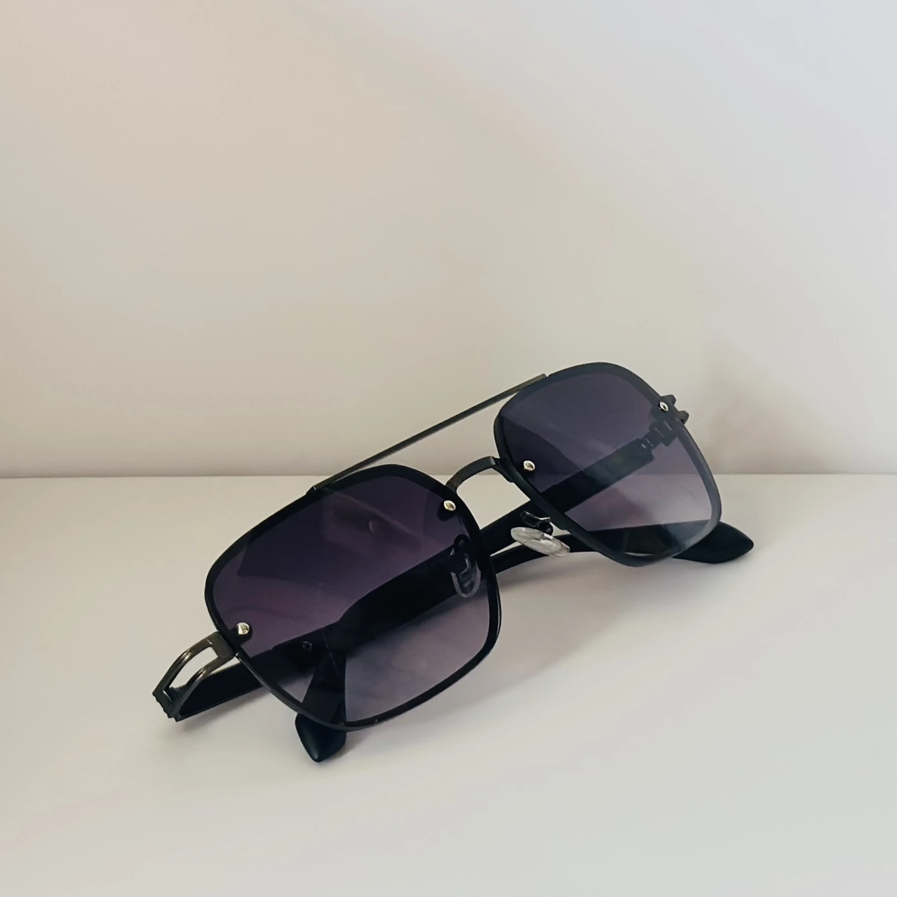 pair of Maybach square-style sunglasses with a black metal frame and dark gradient lenses