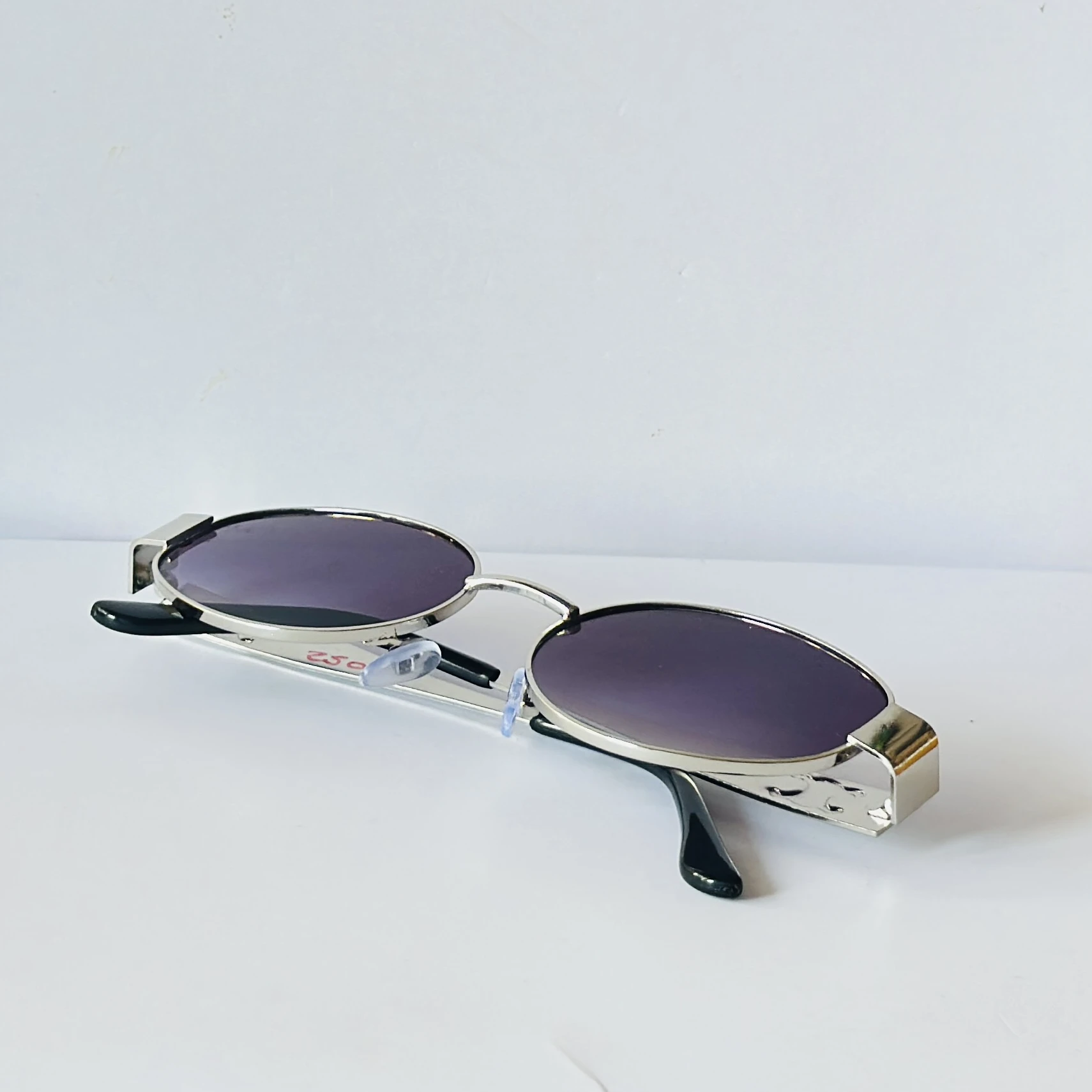 vintage-style metal sunglasses featuring purple oval lenses.