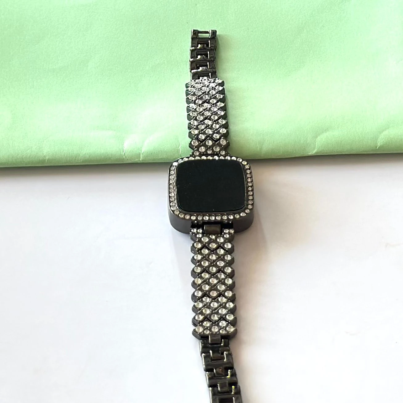 black-toned digital watch with an embellished rhinestone bracelet strap.