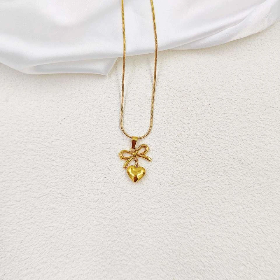 Lumora Forever Gleaming necklace features a heart and bow pendant
